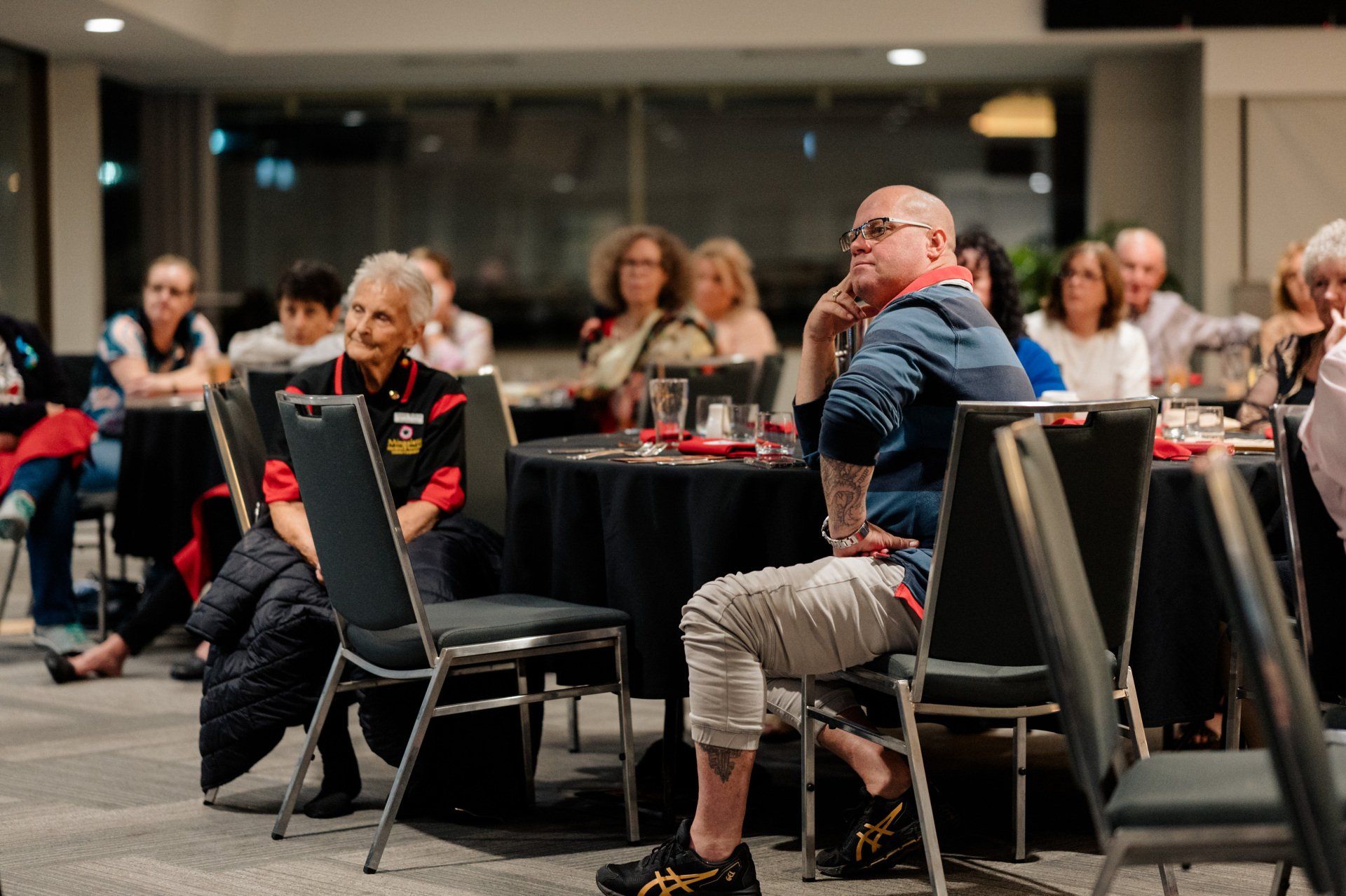 A group of people are sitting at tables in a room.