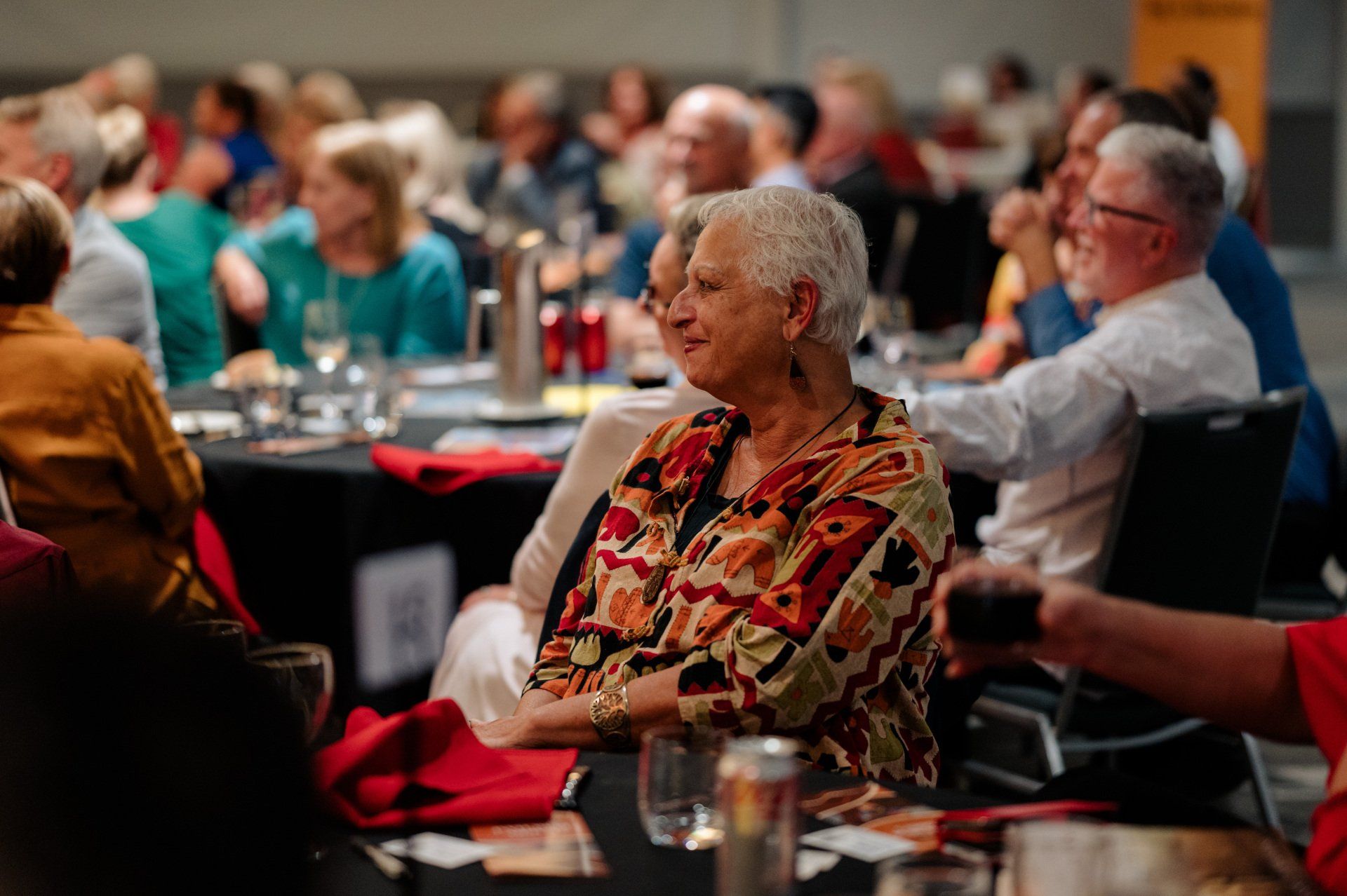 A group of people are sitting at tables in a room.
