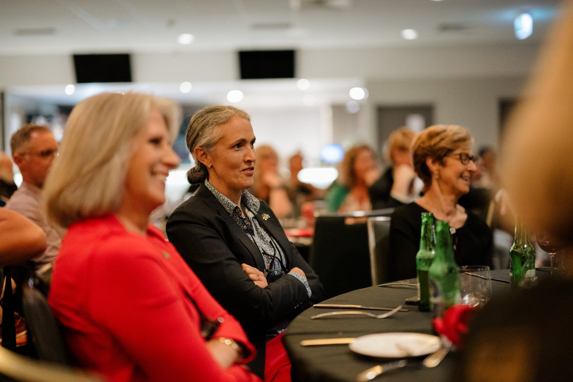 A group of women are sitting at a table at a conference.
