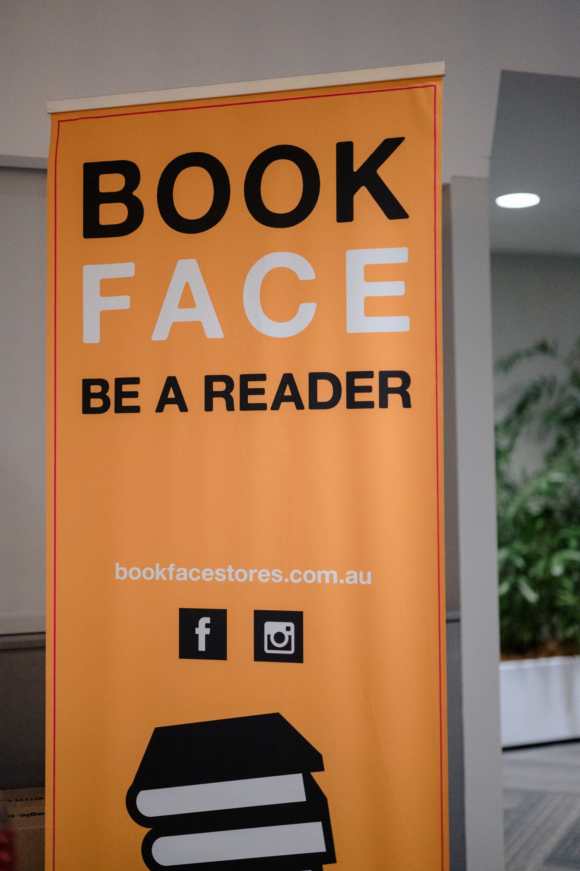 A sign that says book face be a reader