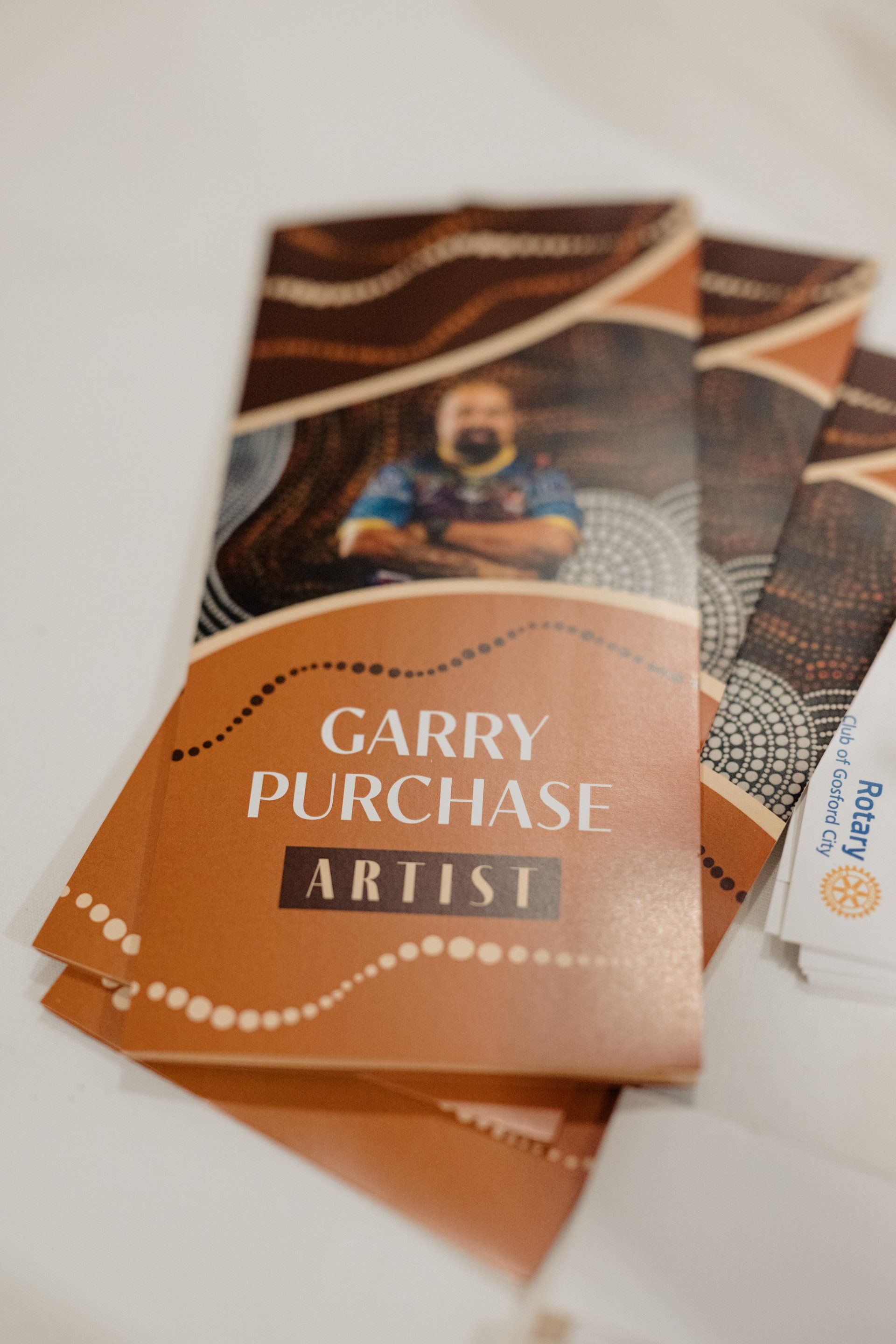 A brochure for garry purchase artist is sitting on a table.