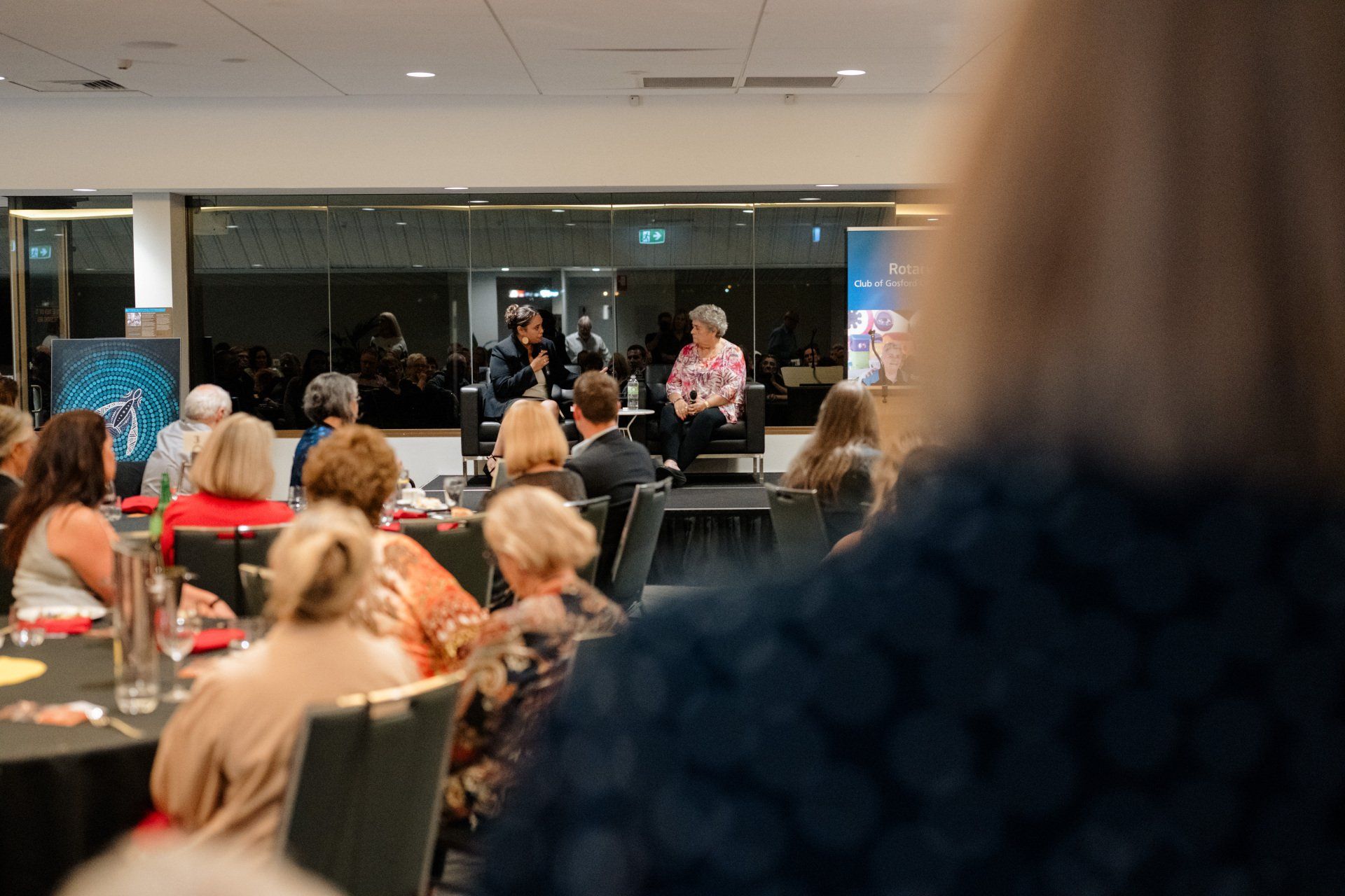 A group of people are sitting at tables in a room.