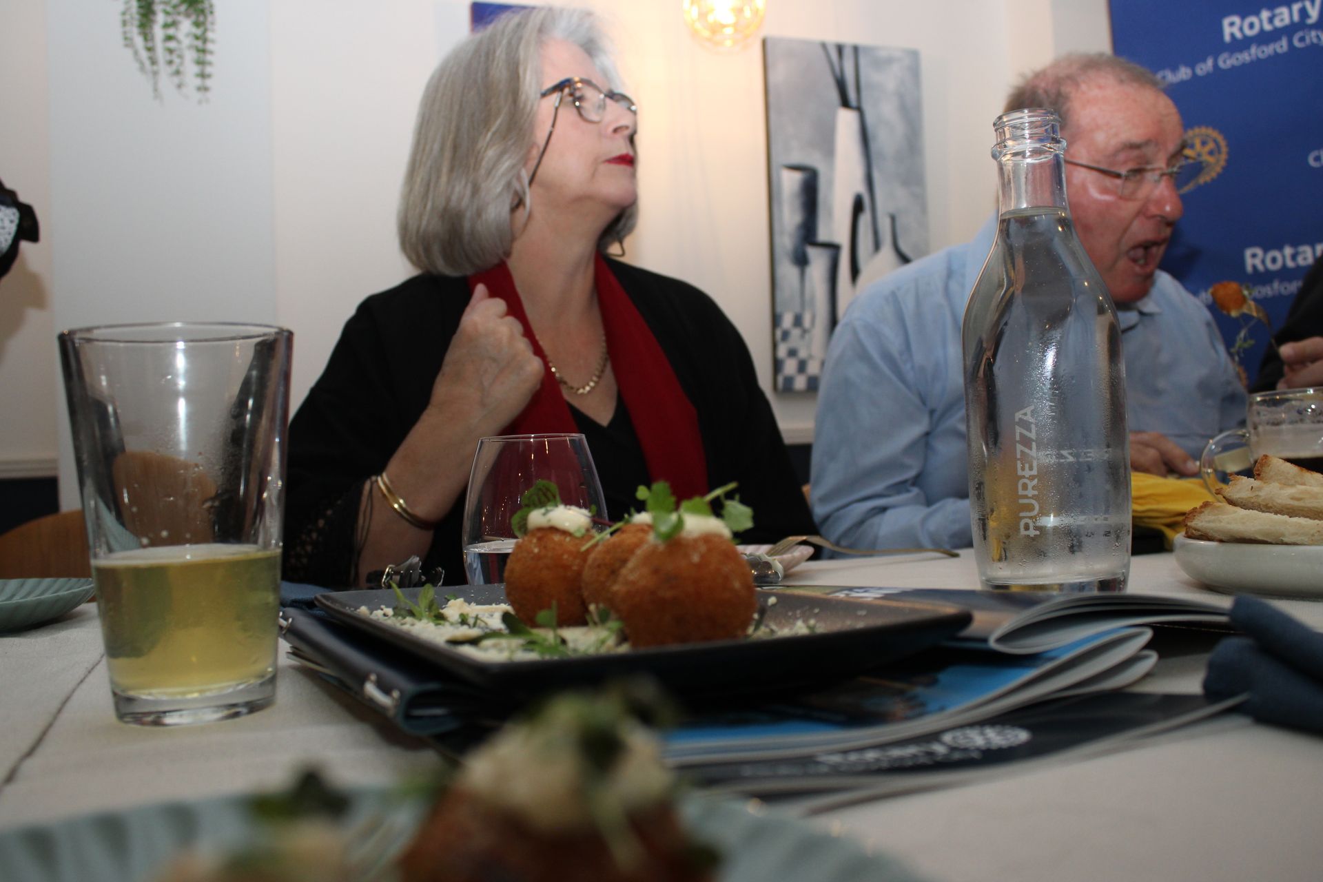 A man and a woman are sitting at a table with plates of food