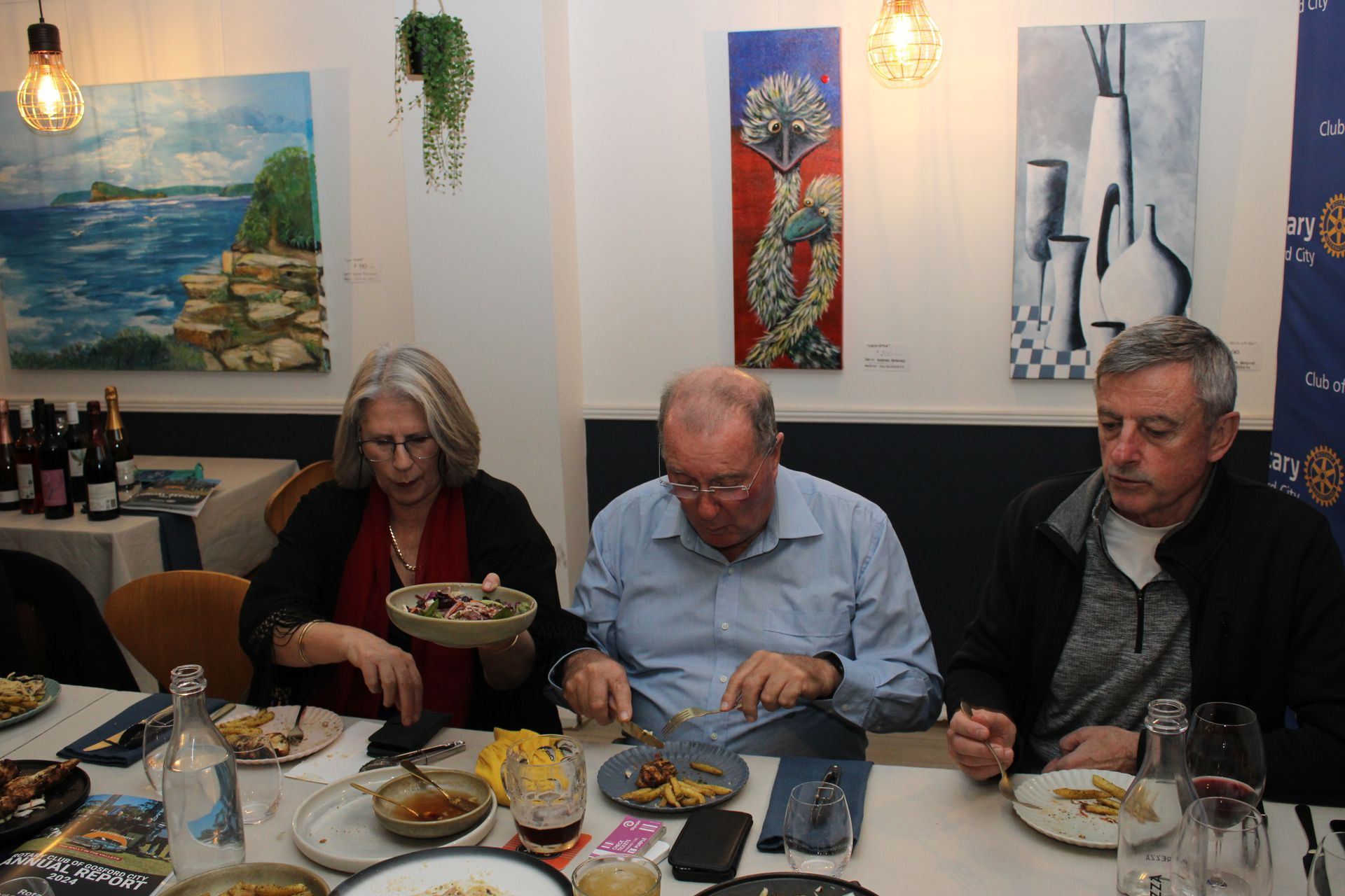 A group of people are sitting at a table eating food.