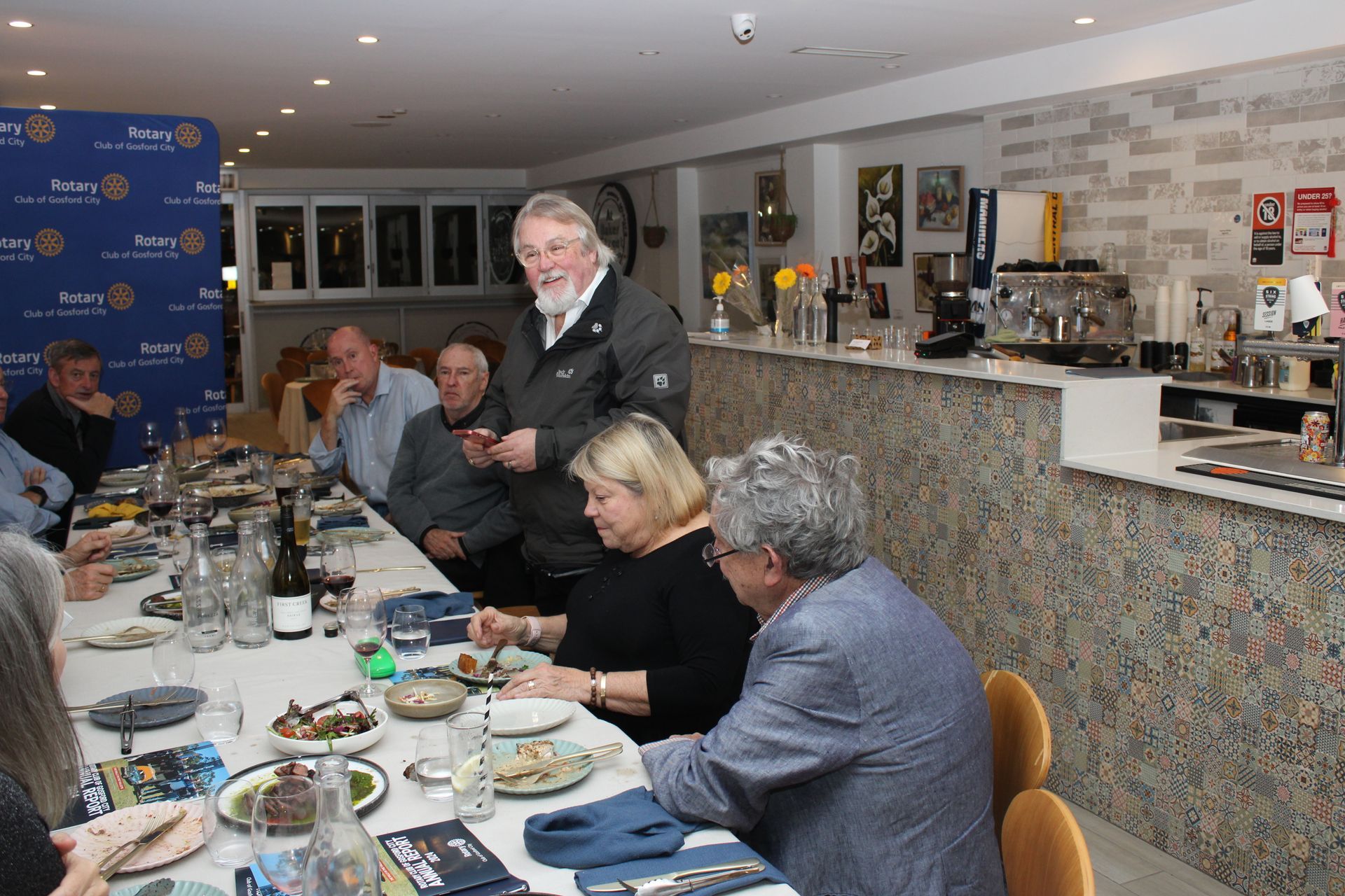 A group of people are sitting at a long table in a restaurant.