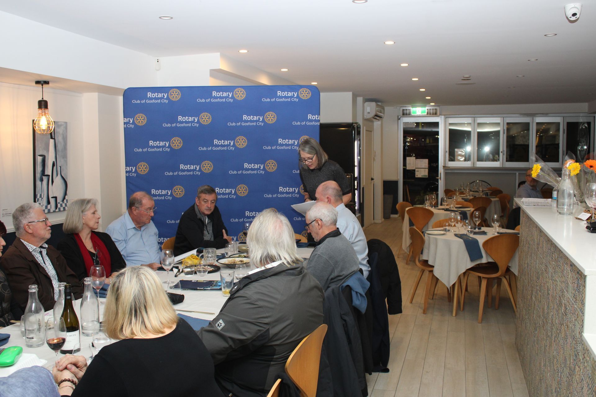 A group of people are sitting at tables in a restaurant.