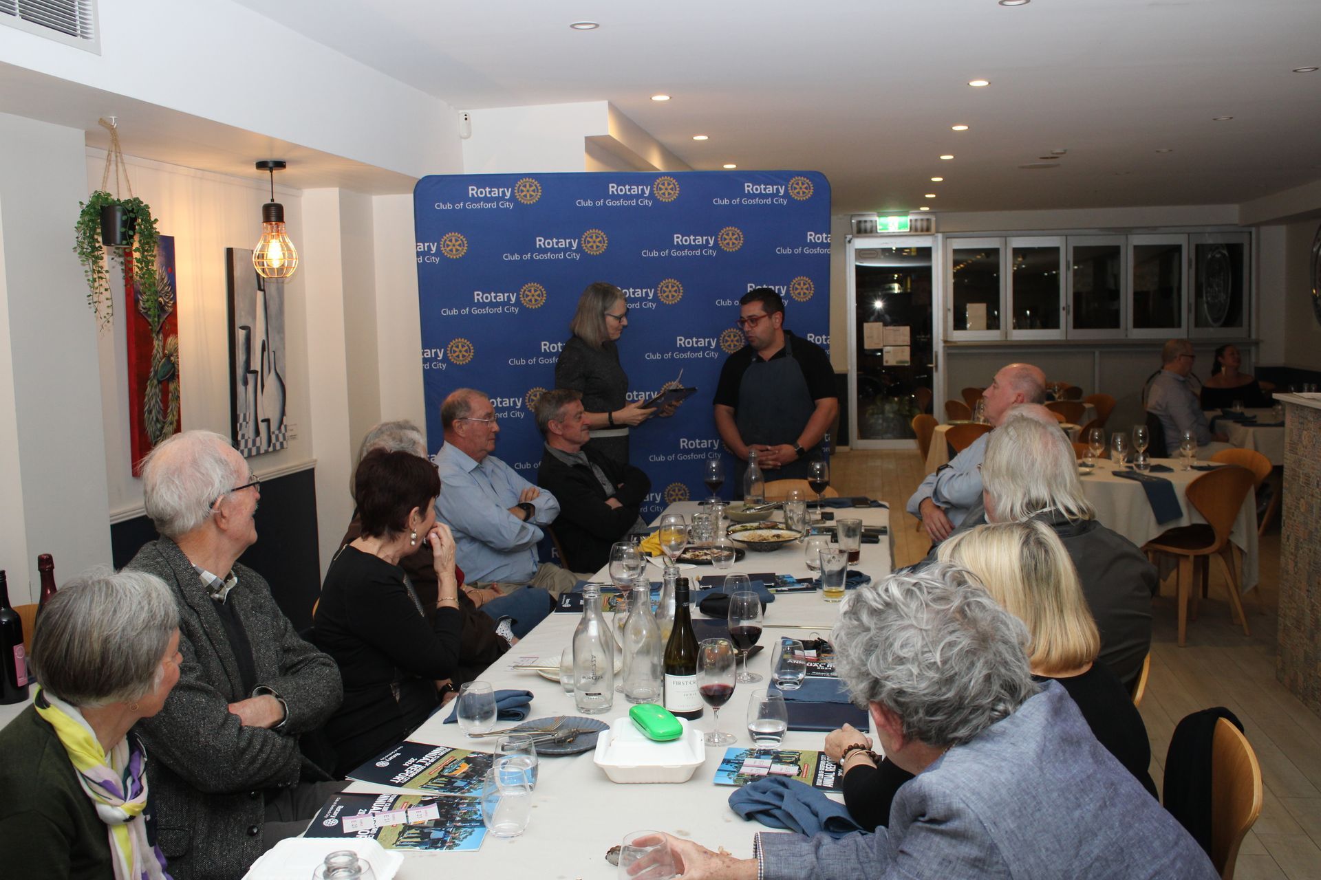 A group of people are sitting around a table in a restaurant.
