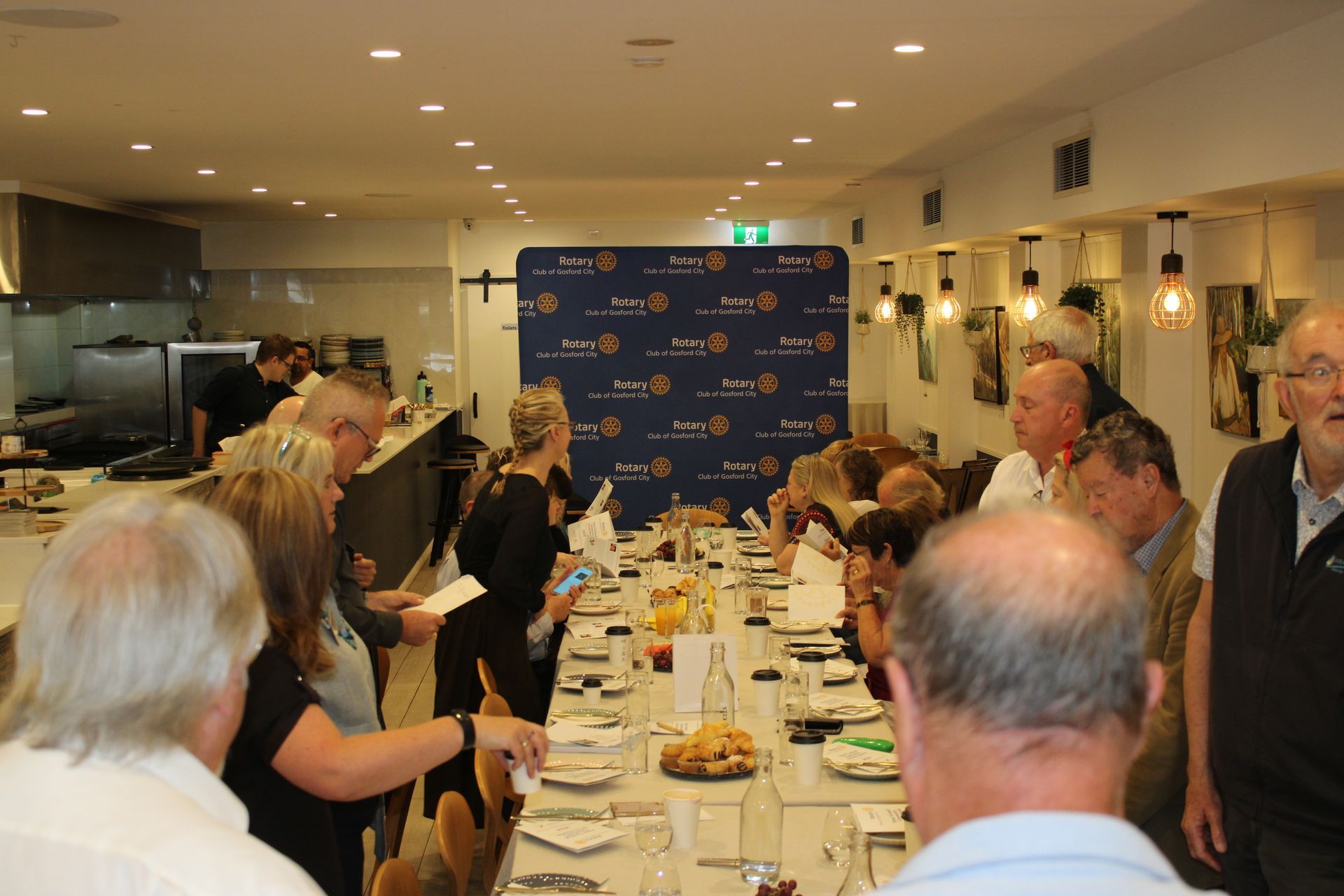 A group of people are sitting at a long table in a restaurant.
