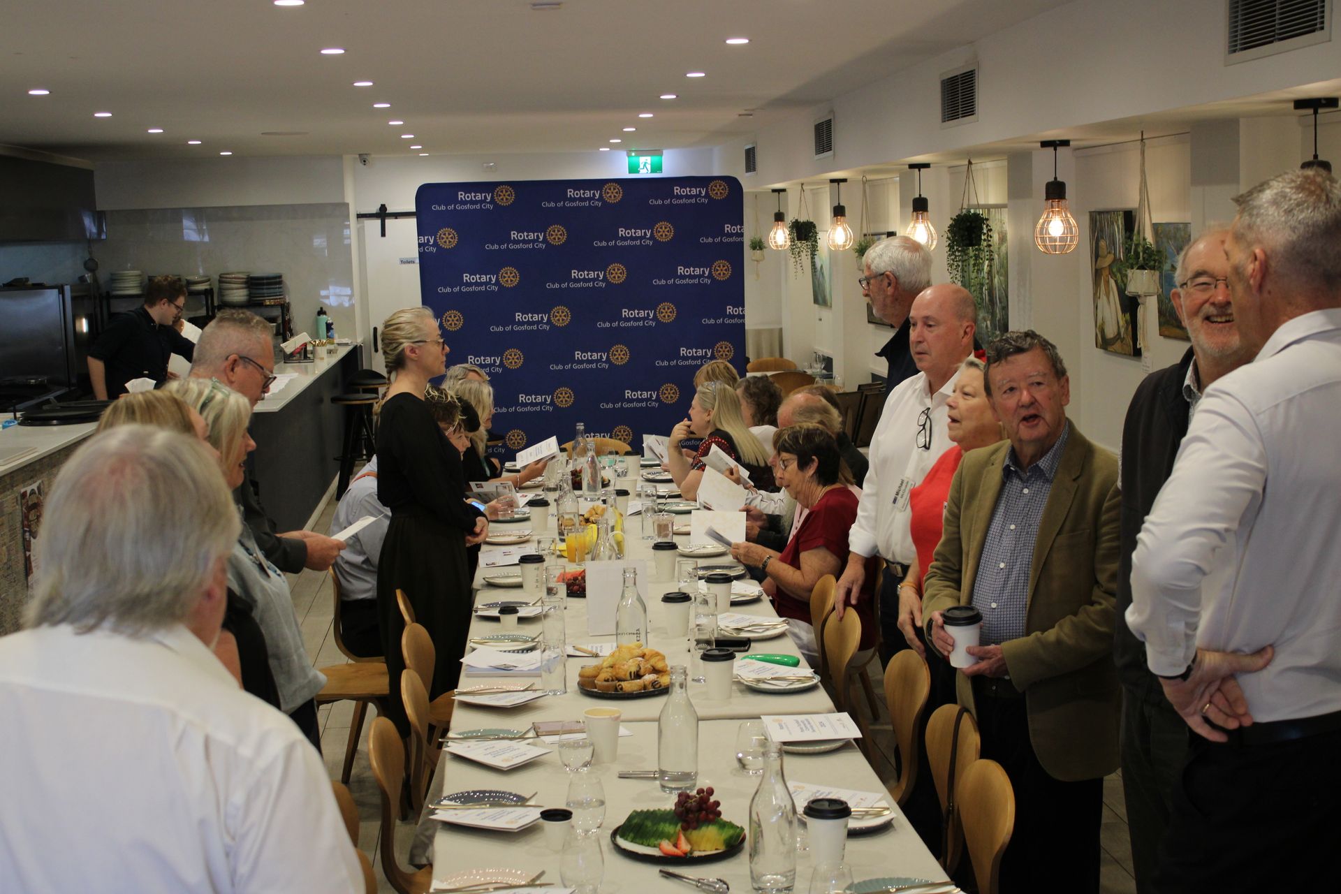 A group of people are sitting at a long table in a restaurant.