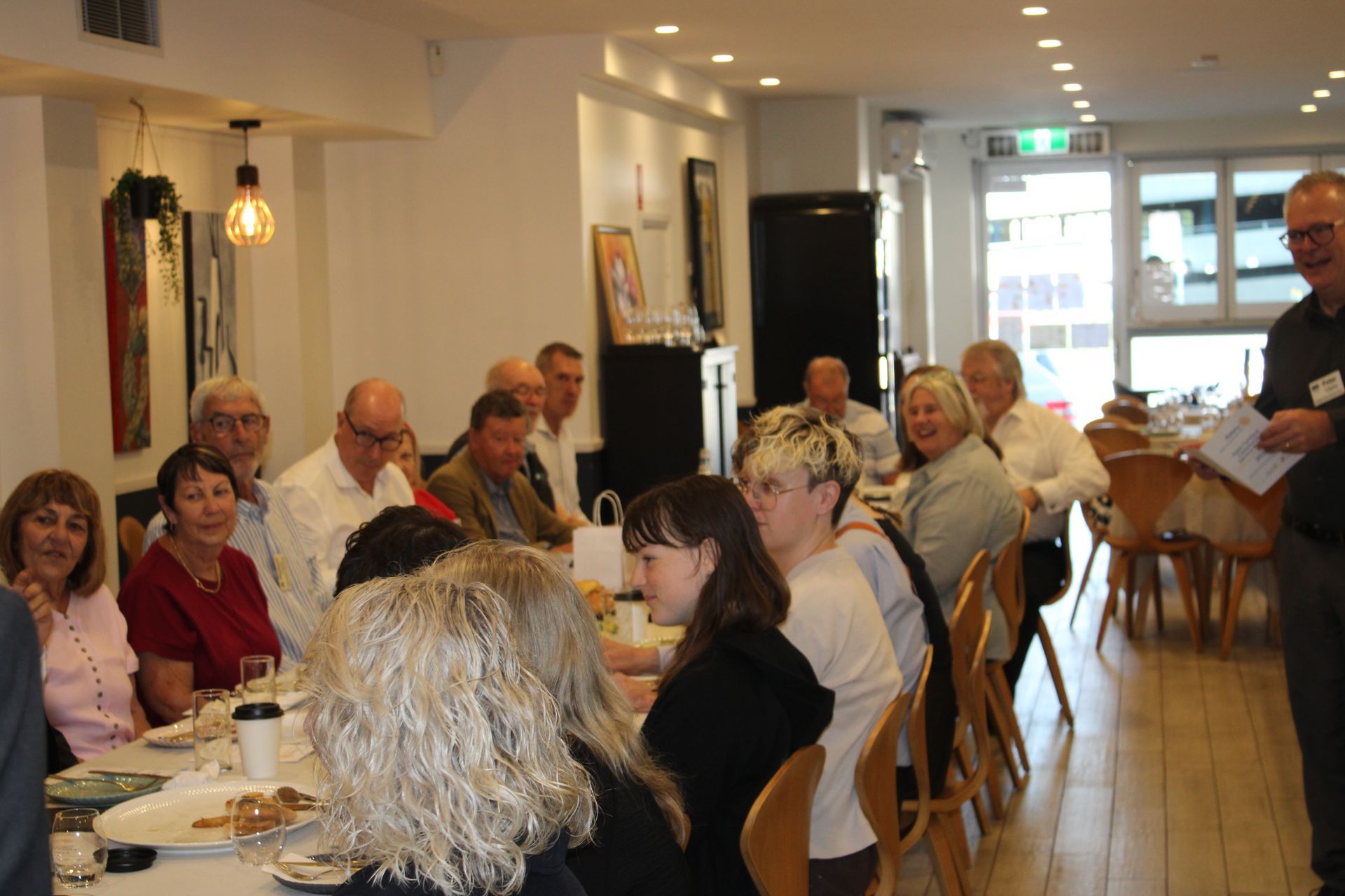 A group of people are sitting at tables in a restaurant.