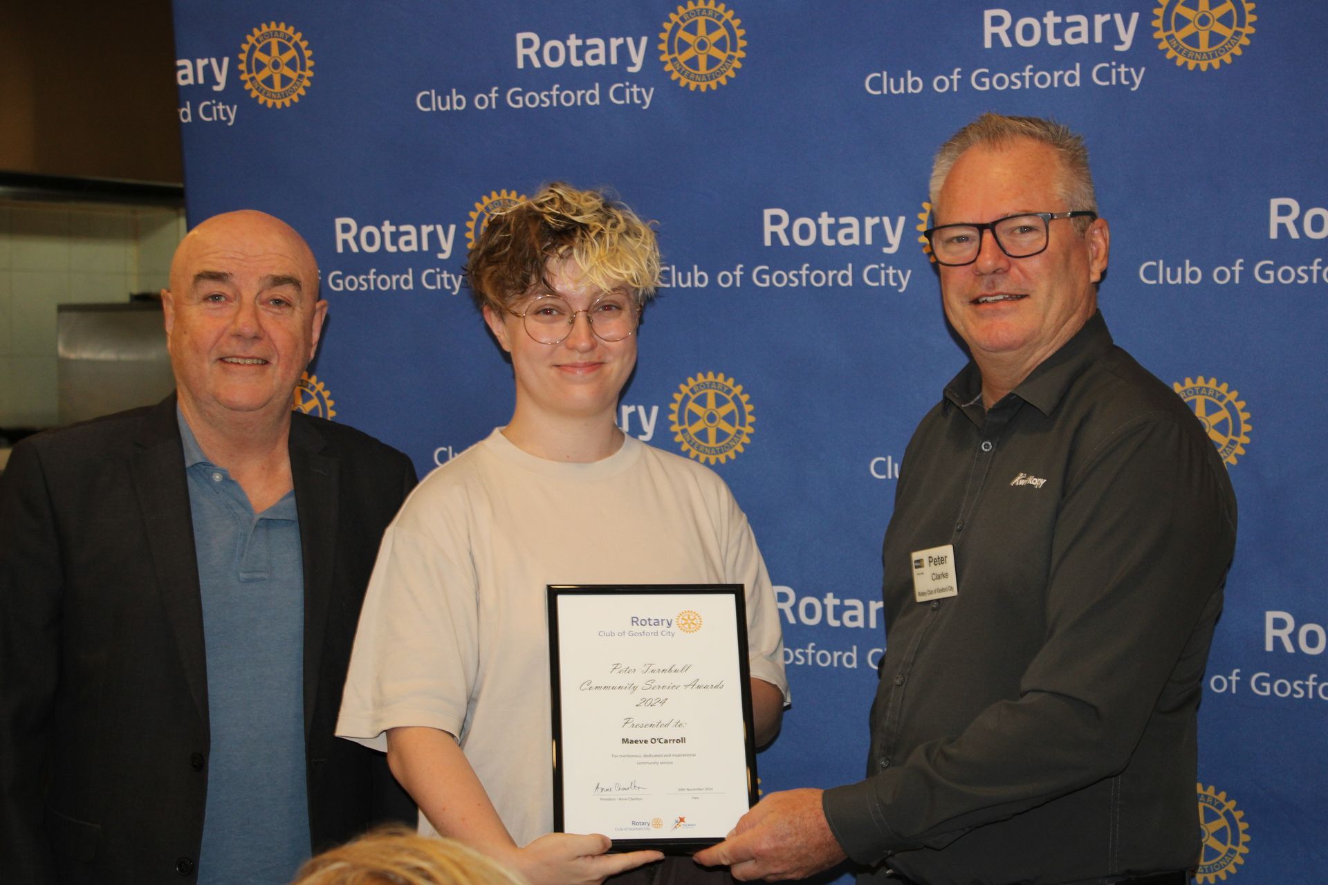 Three men are standing next to each other holding a certificate.