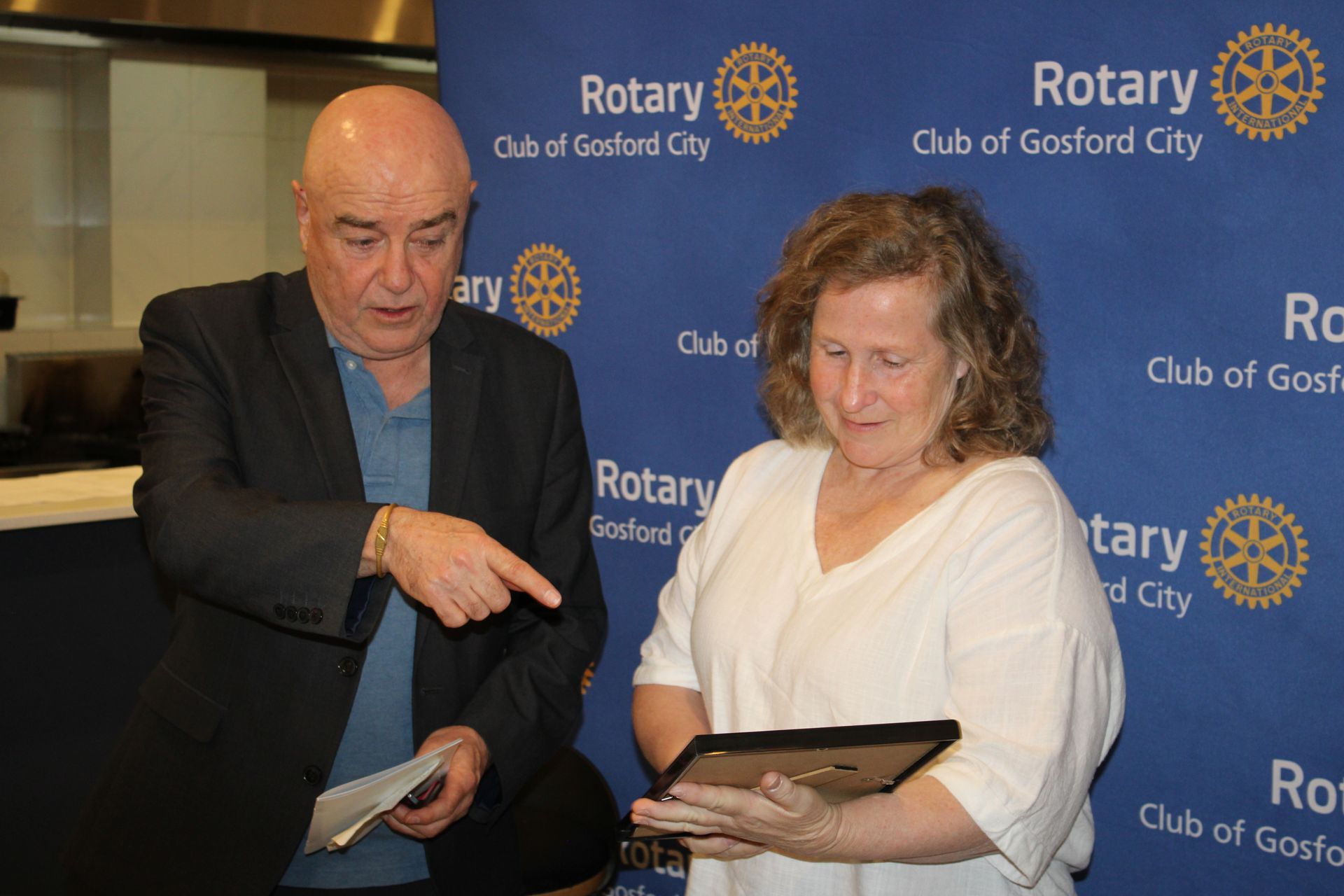 A man and a woman are looking at a tablet.