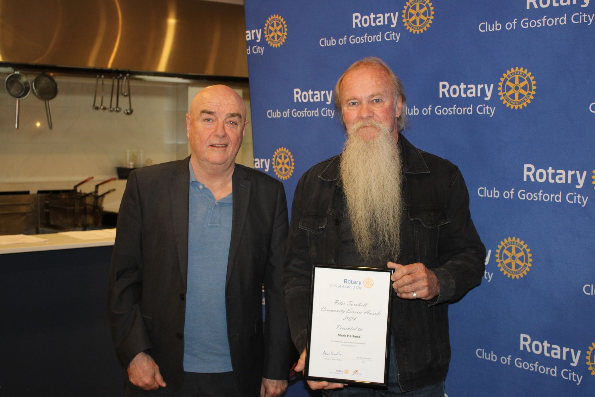 Two men are standing next to each other holding a certificate.