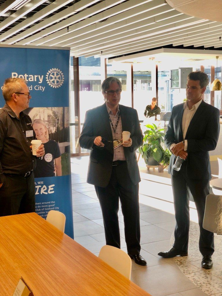 Three men in suits are standing next to each other in a room.