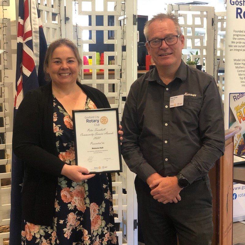 A man and a woman holding a rotary certificate