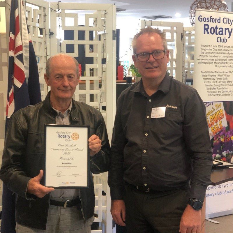 Two men standing next to each other holding a rotary certificate