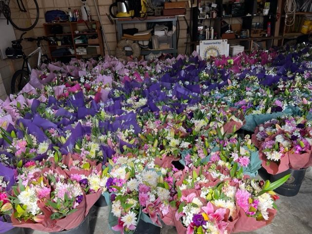 A bunch of flowers are sitting on a table in a garage