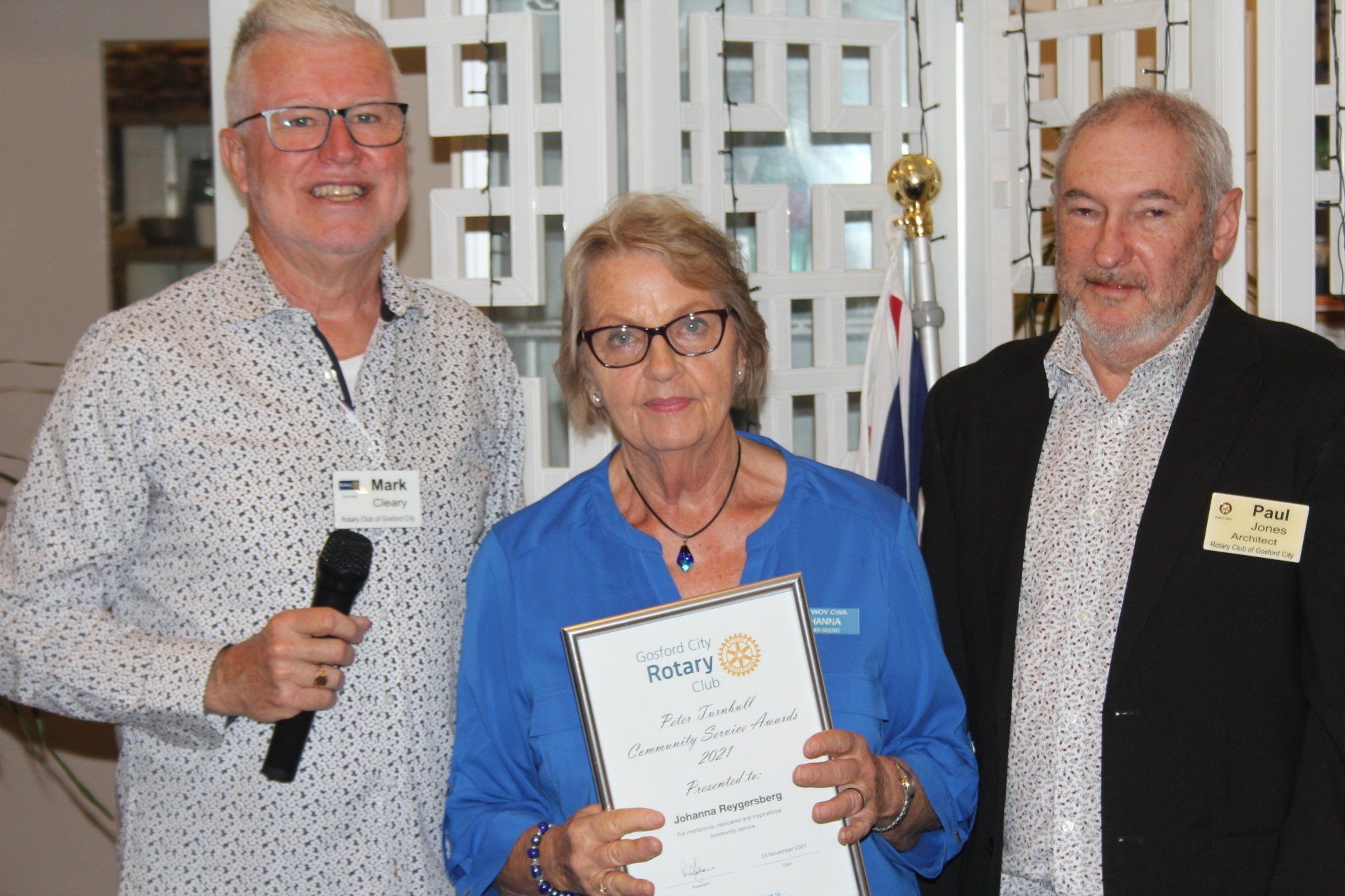 Two men and a woman are standing next to each other holding a certificate.