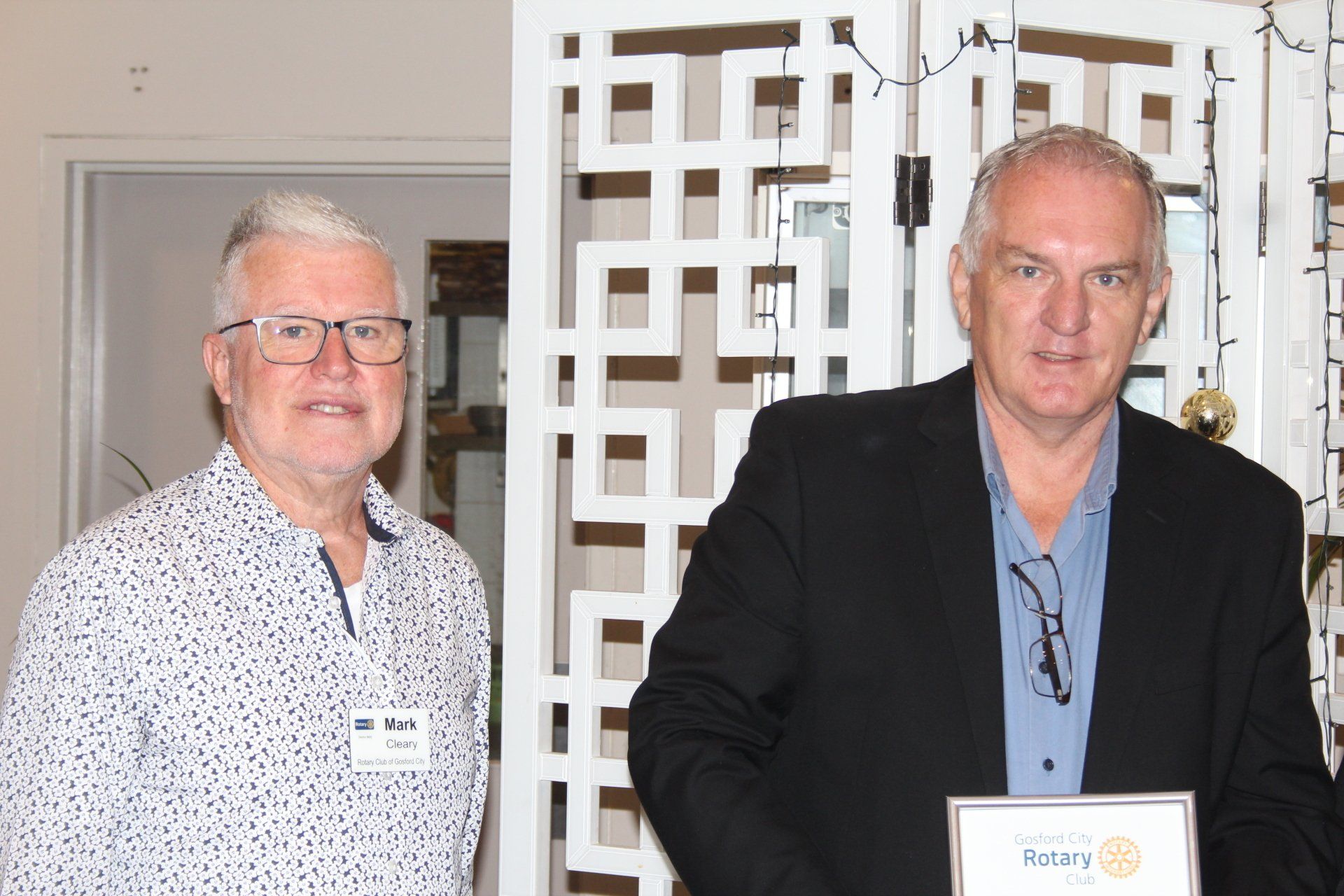 Two men are standing next to each other in a room.