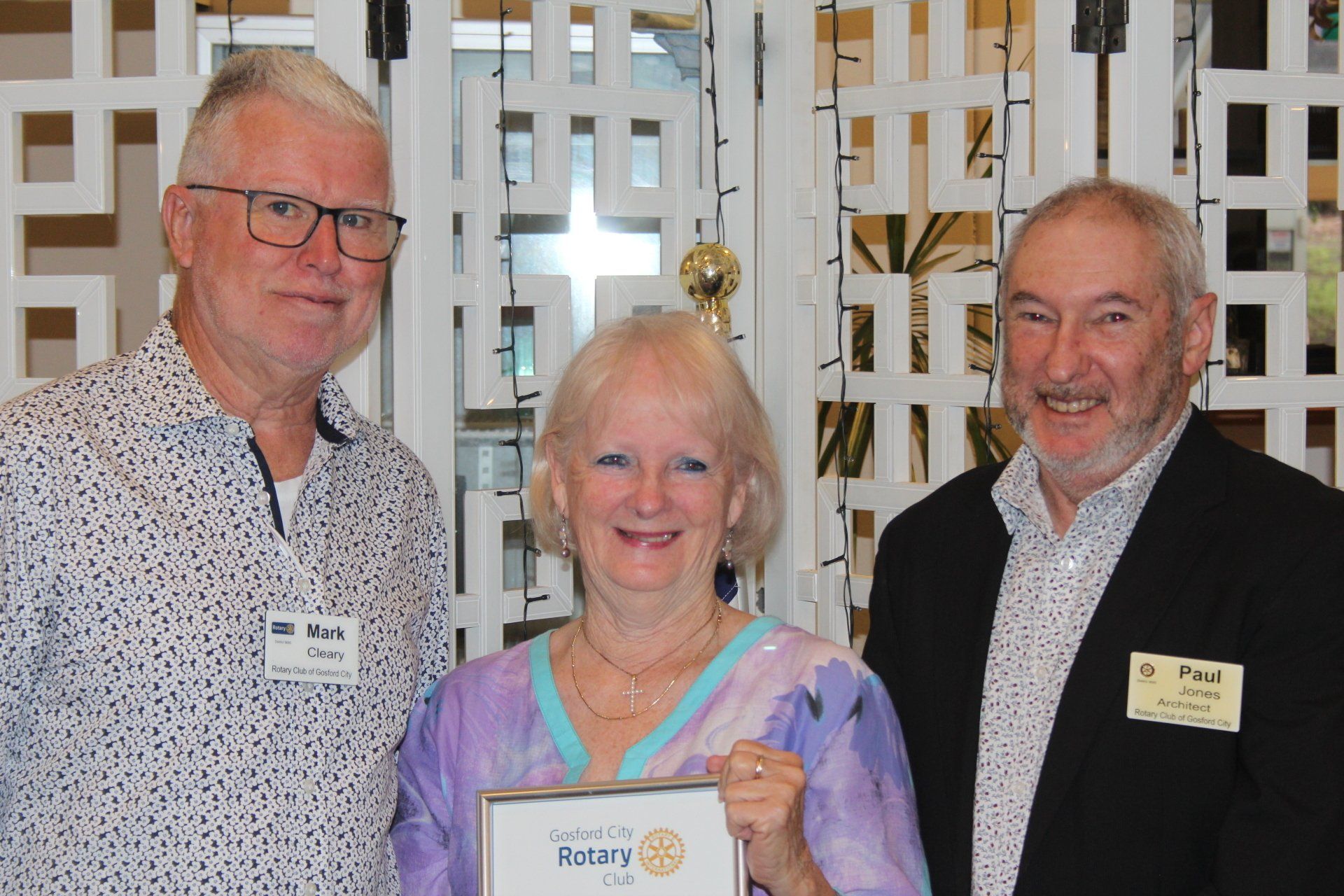A woman is holding a certificate that says rotary on it