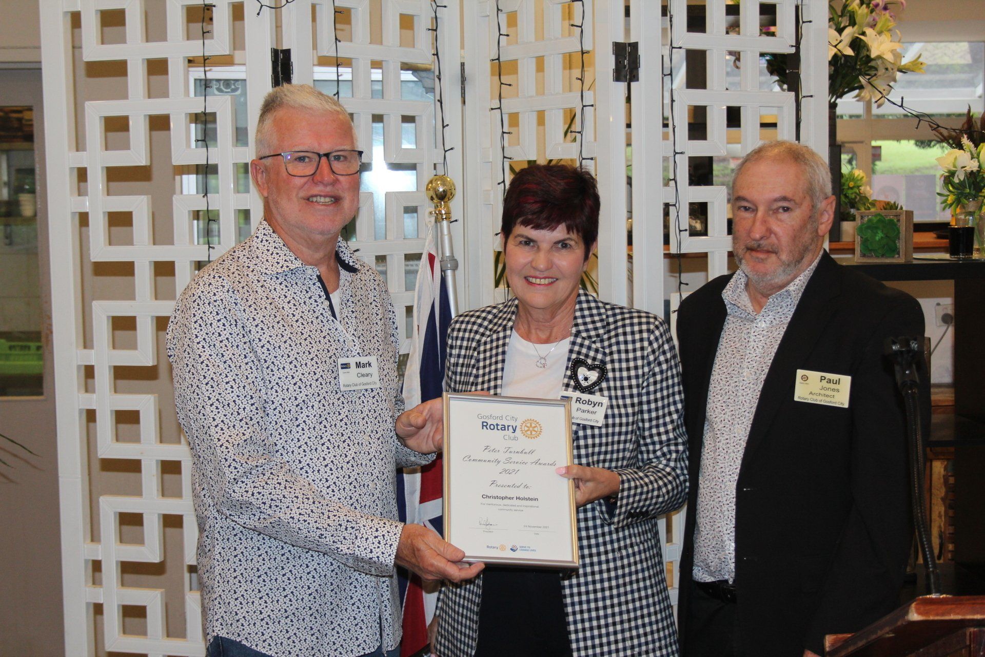 Two men and a woman are standing next to each other holding a certificate.