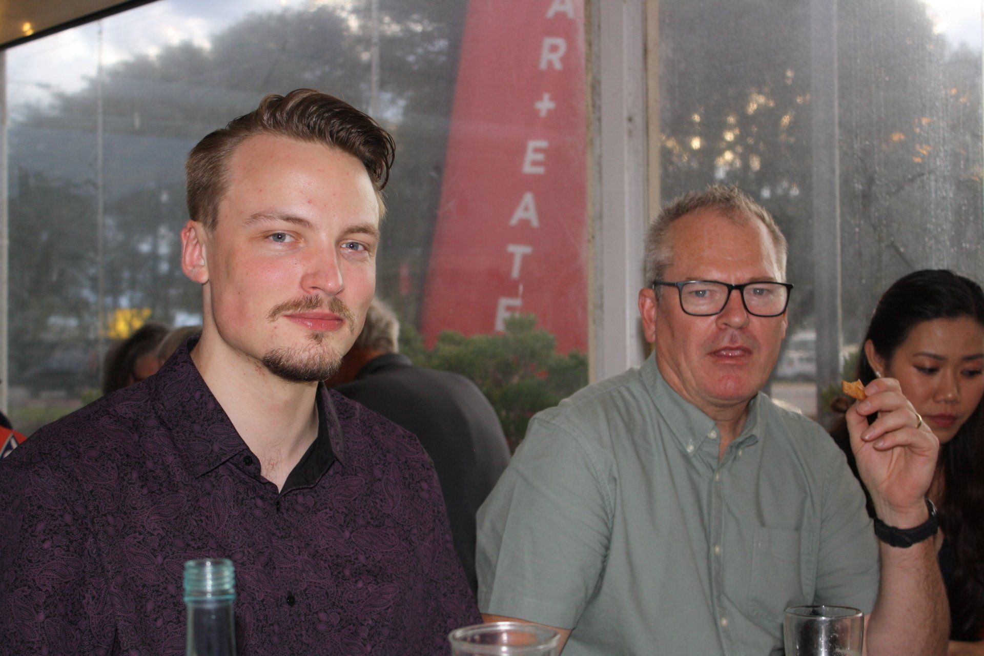A man and a woman are sitting at a table in a restaurant.