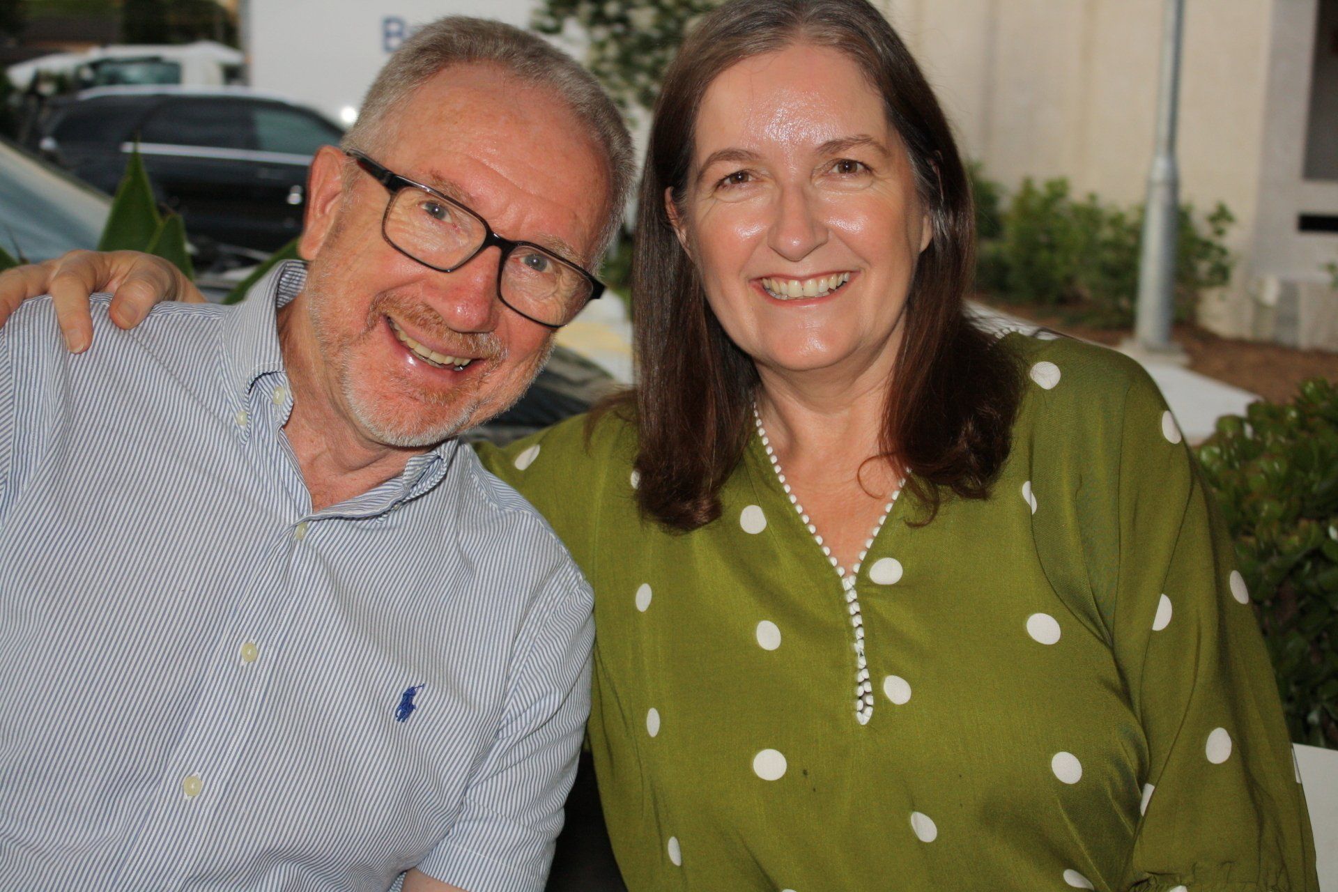 A man and a woman are posing for a picture together and smiling.