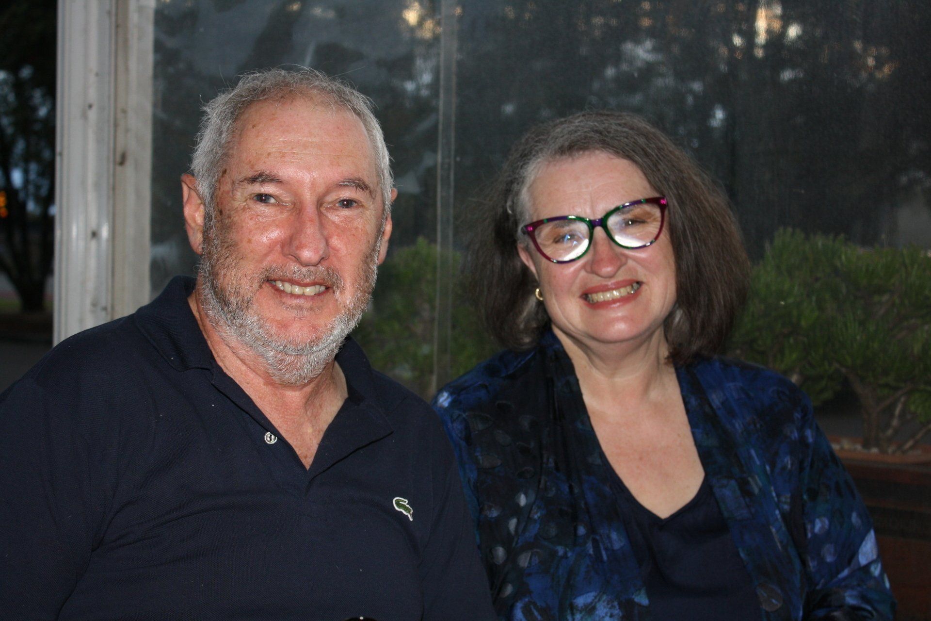 A man and a woman are posing for a picture together and smiling.