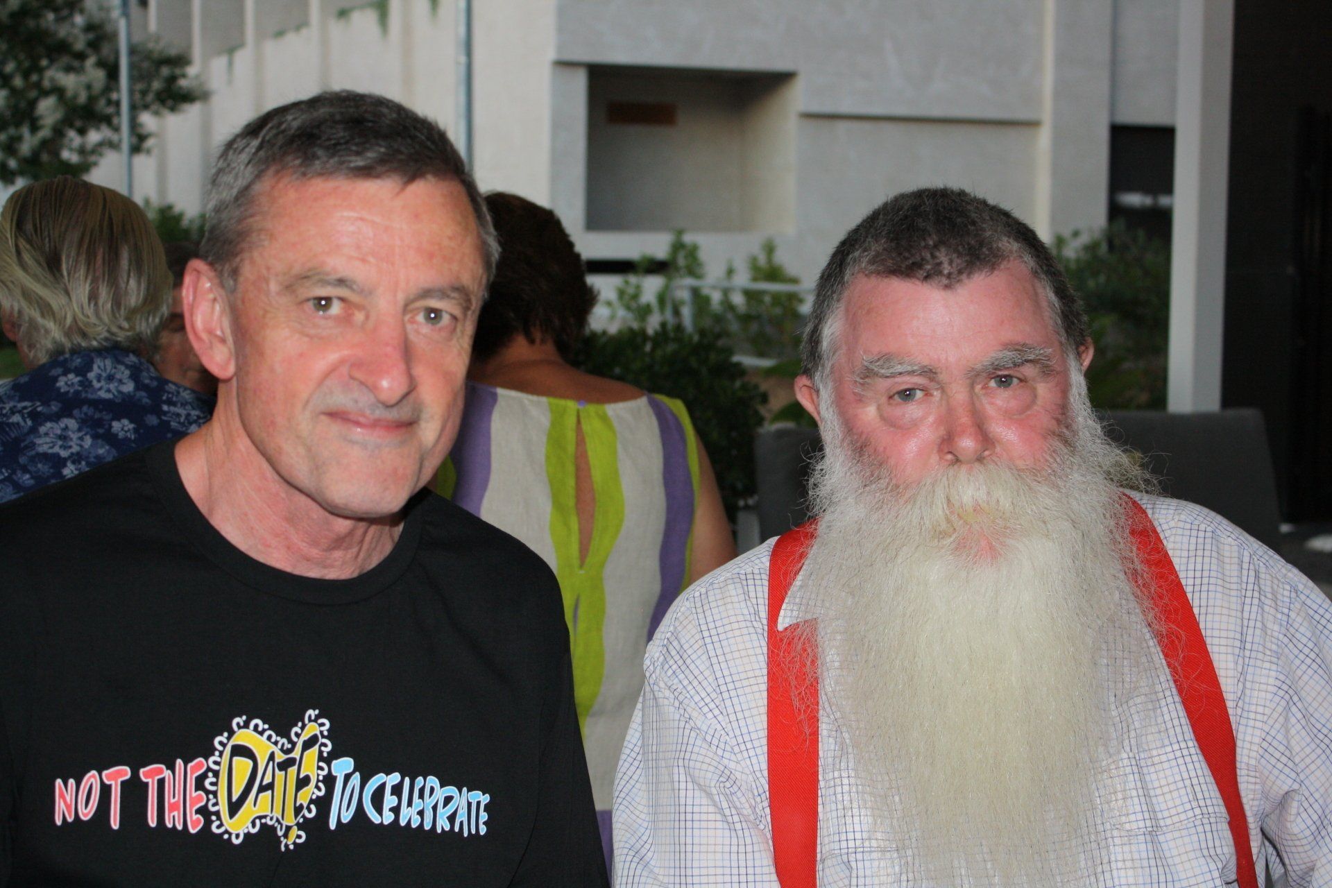 Two men standing next to each other with one wearing a shirt that says not the date to celebrate