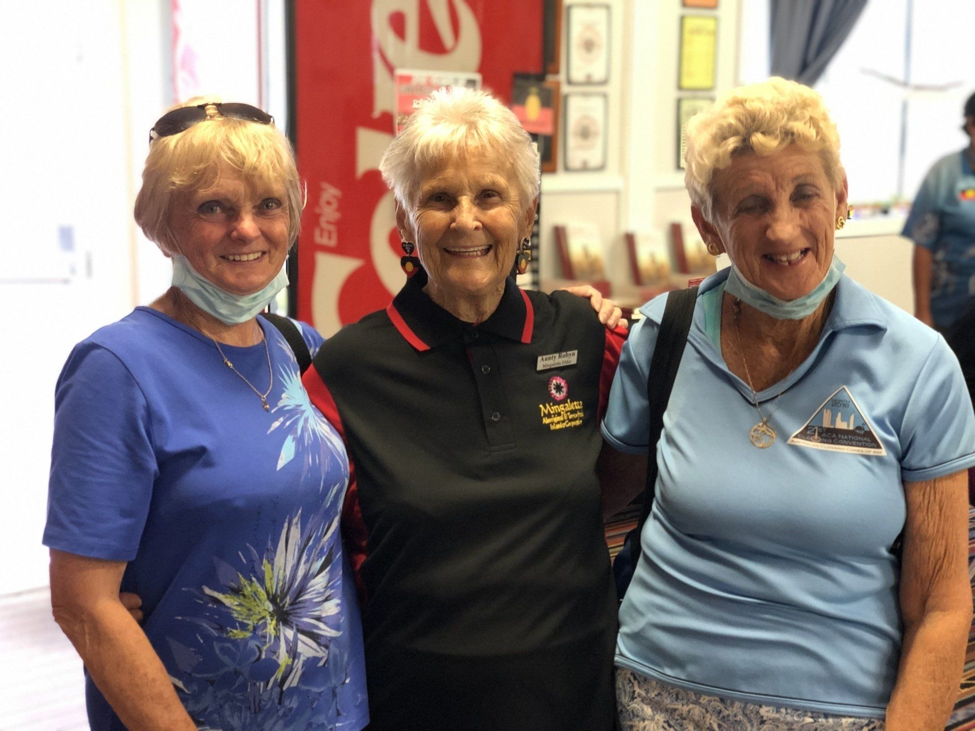 Three older women wearing face masks are posing for a picture.