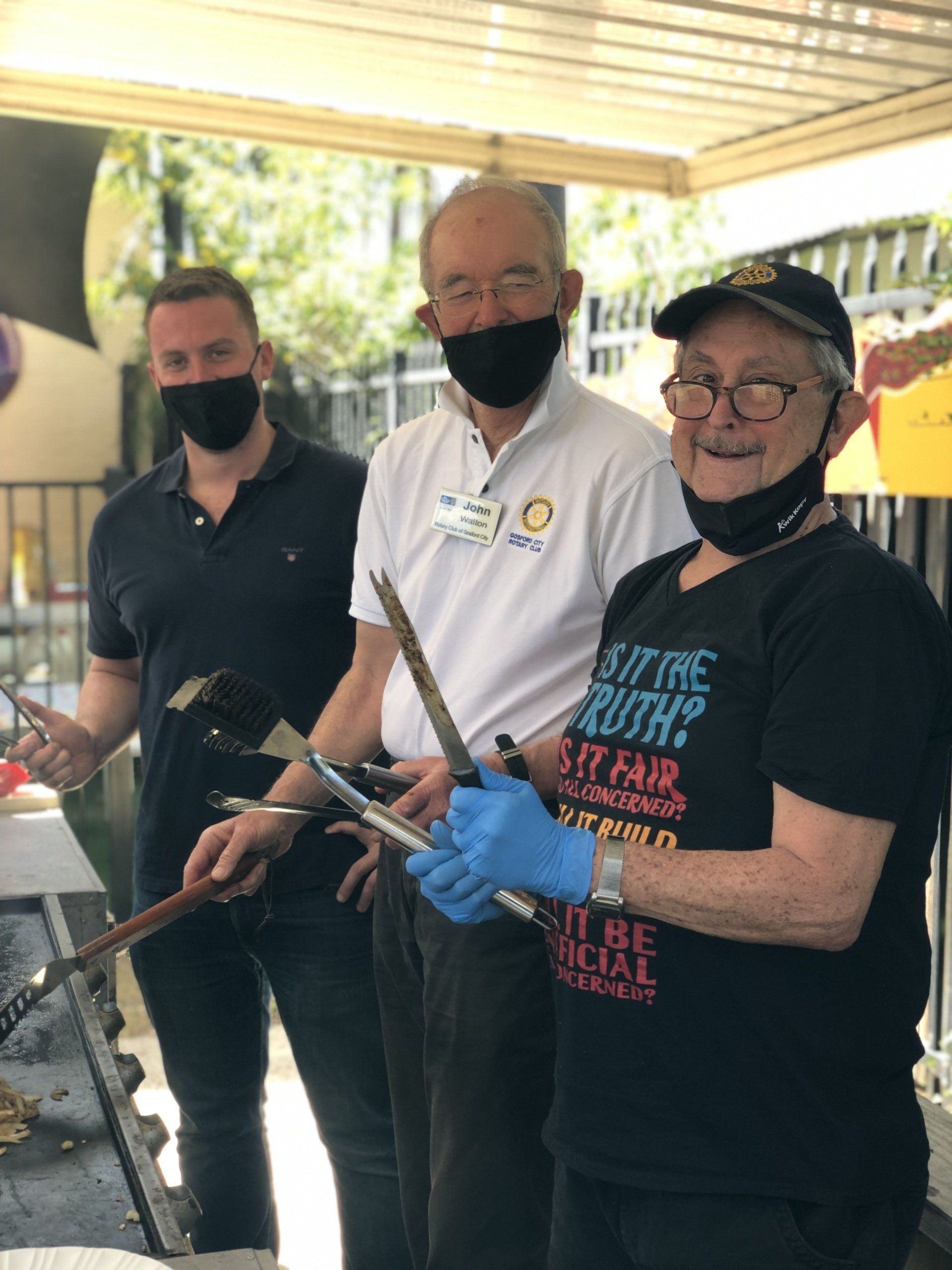 A group of people wearing masks and gloves are standing next to each other.