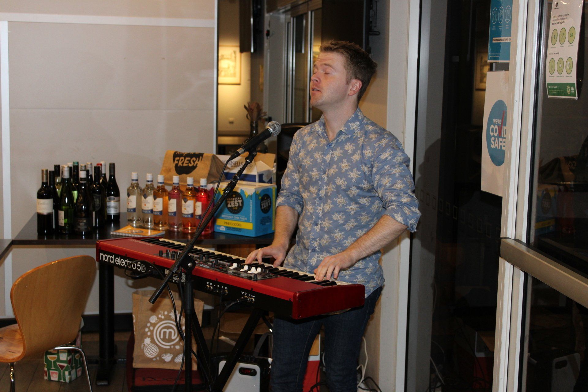 A man is playing a keyboard and singing into a microphone