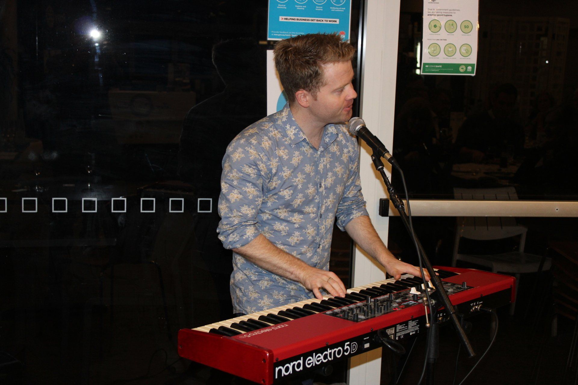A man is playing a keyboard and singing into a microphone.