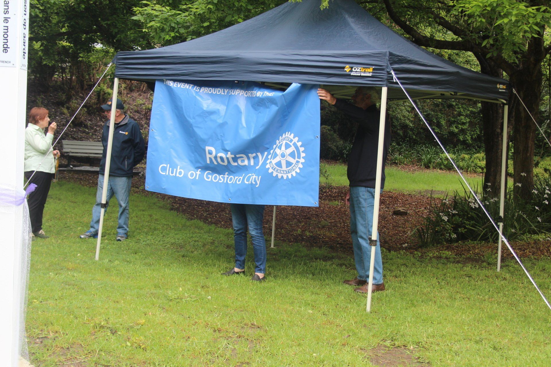 A group of people holding a blue banner that says rotary