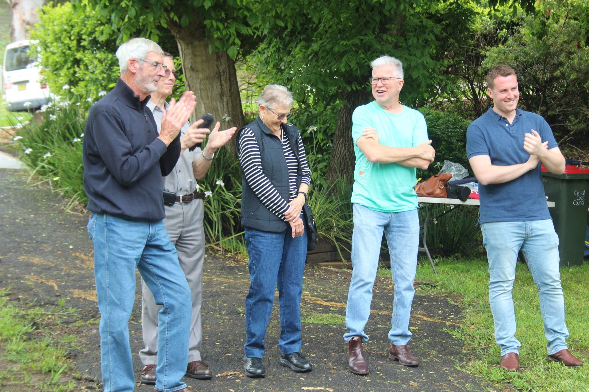 A group of men are standing next to each other and clapping.