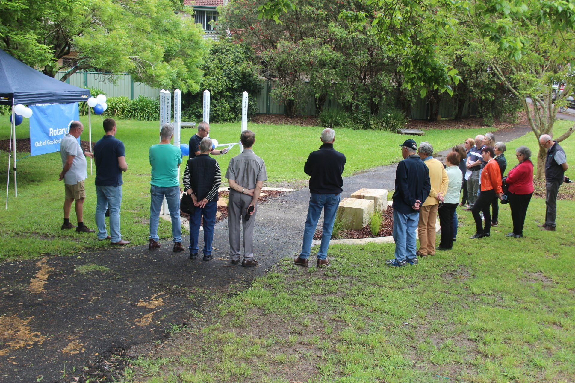 A group of people are standing in a grassy field.