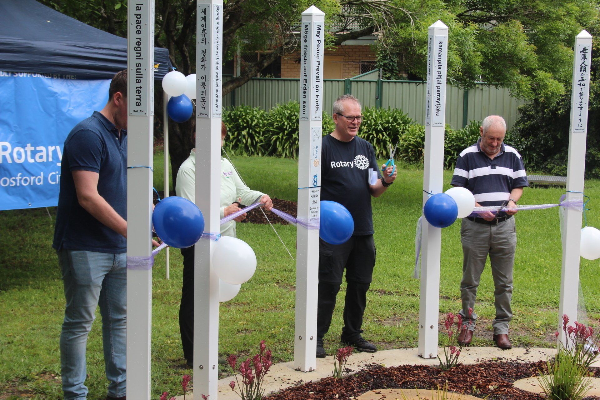 A group of people are standing next to each other holding balloons and ribbons.
