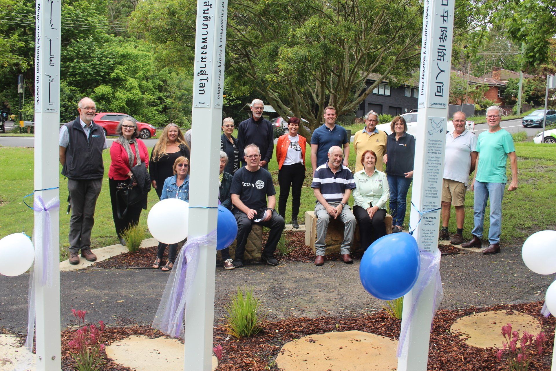 A group of people are posing for a picture in a park.