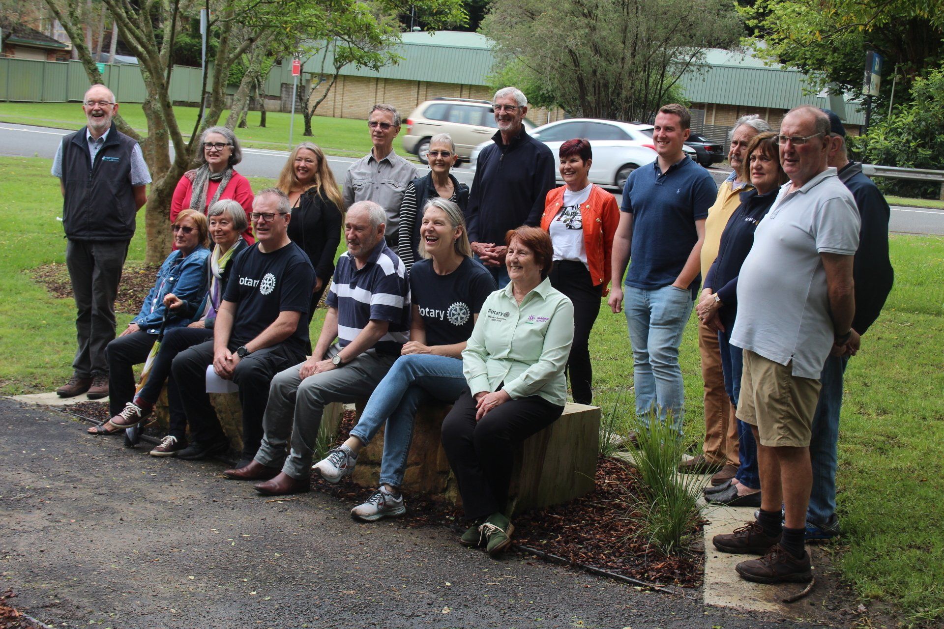 A group of people are posing for a picture in a park.