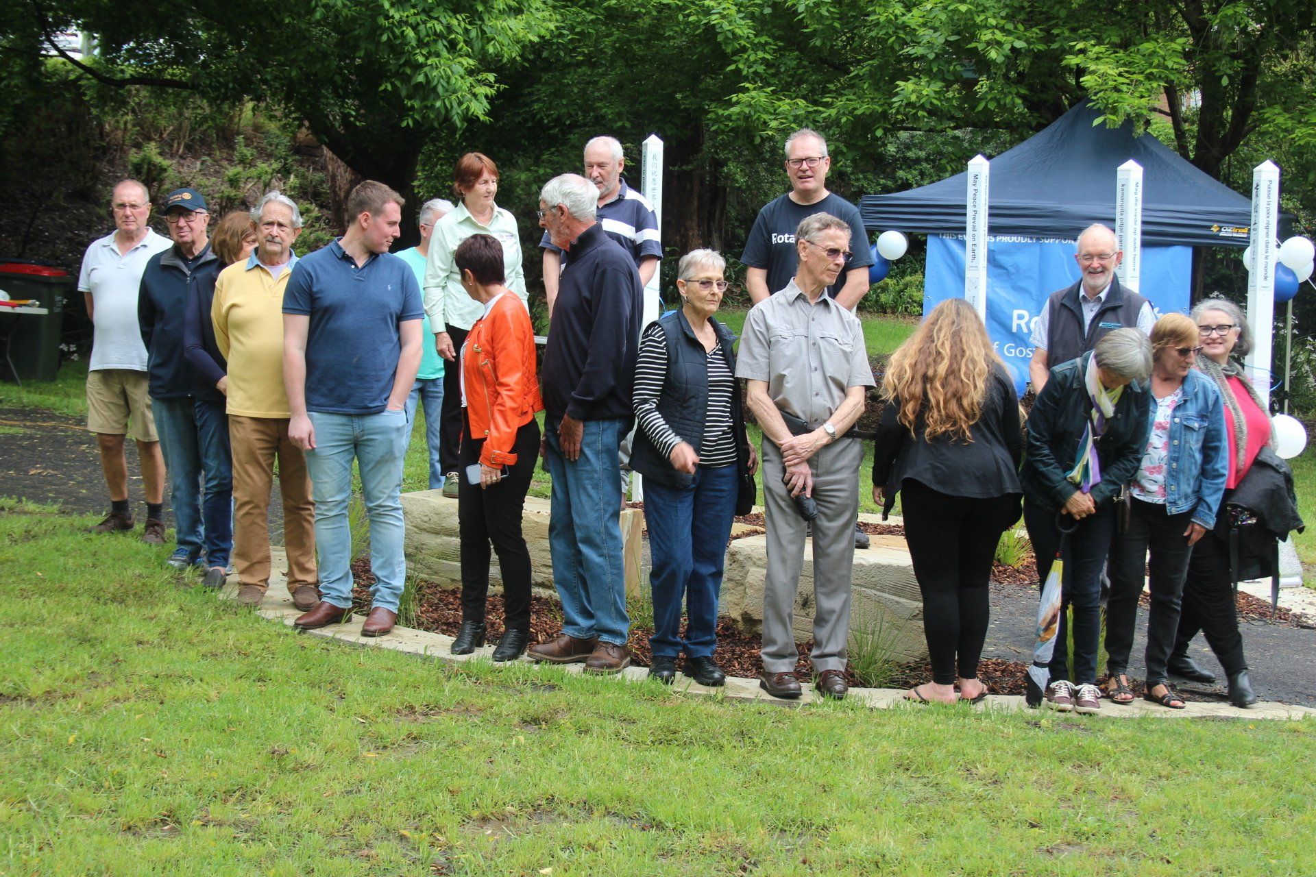 A group of people are standing in a grassy field.
