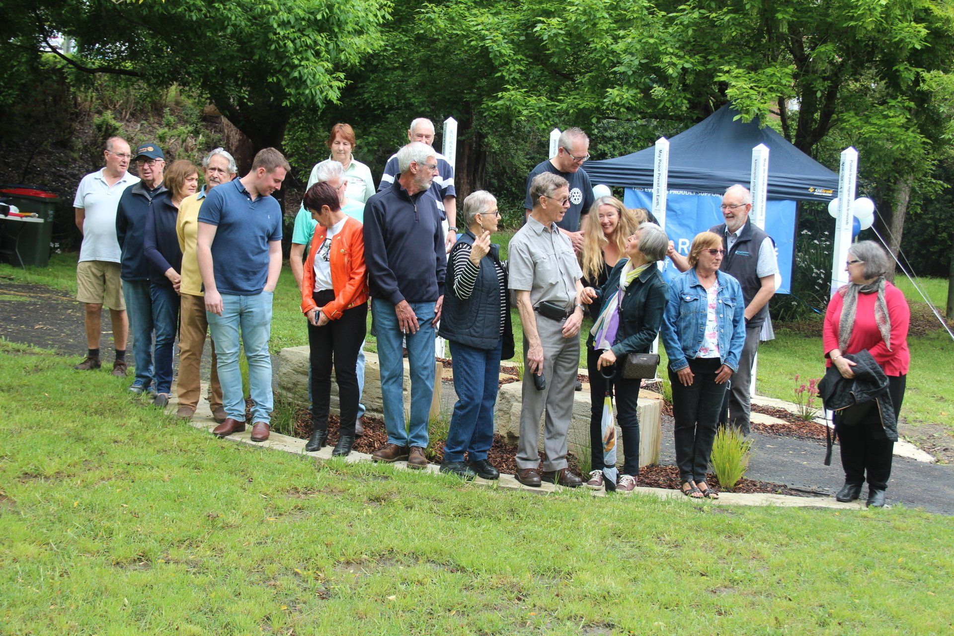 A group of people are standing in a grassy field.