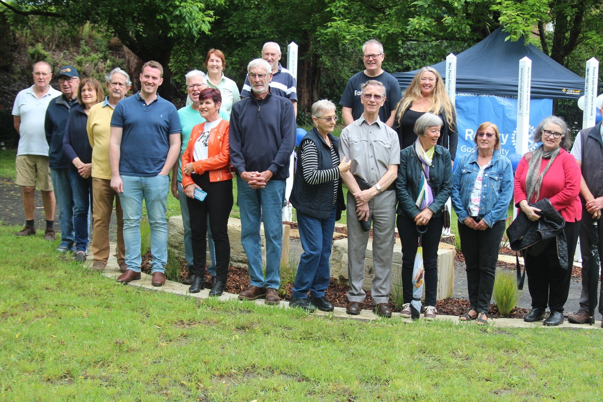 A group of people are posing for a picture in a park.