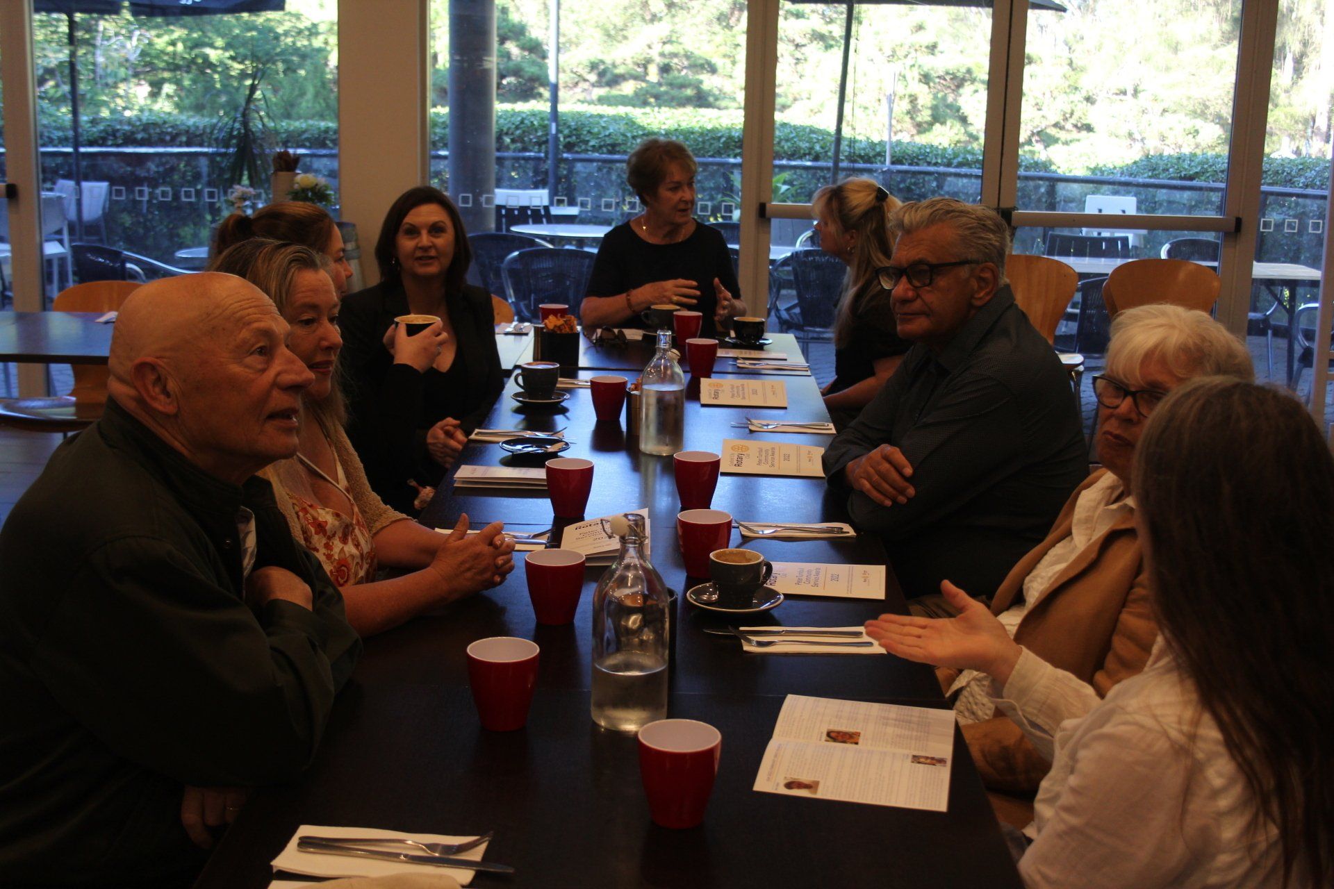 A group of people are sitting around a long table