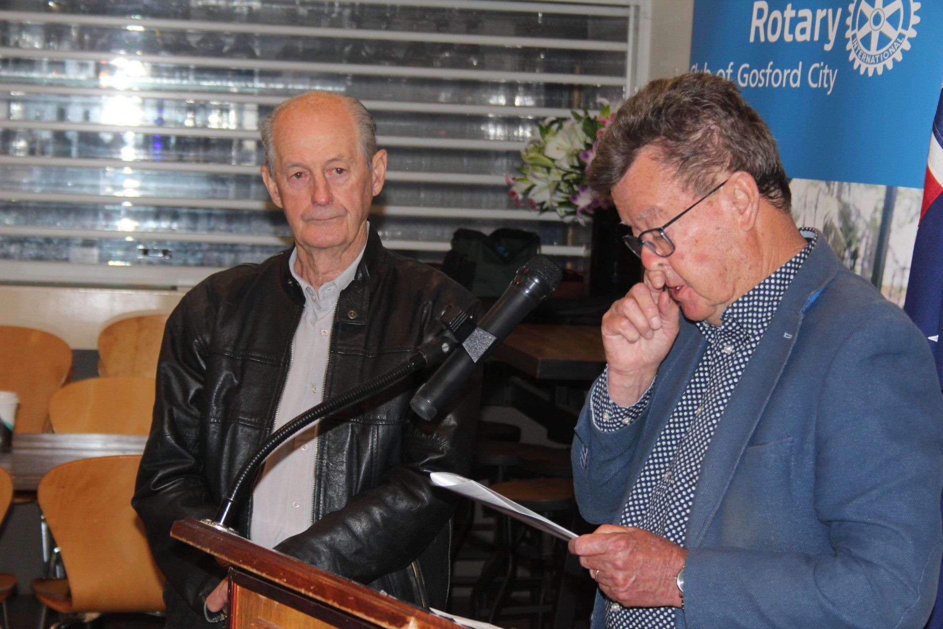 Two men are standing next to each other at a podium.