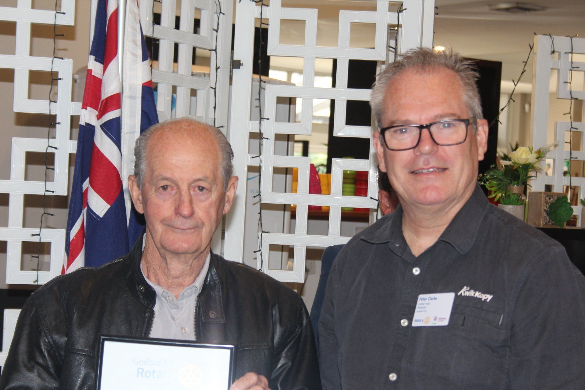 Two men are standing next to each other holding a certificate.