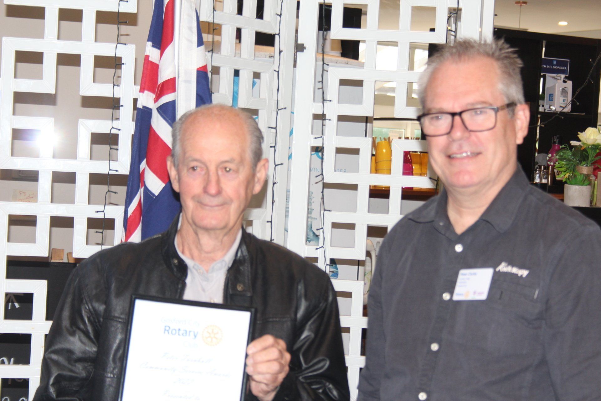 Two men are standing next to each other and one is holding a certificate that says rotary