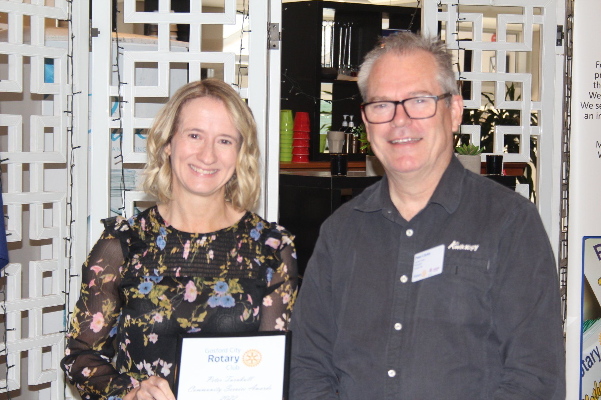 A man and a woman are standing next to each other holding a certificate.