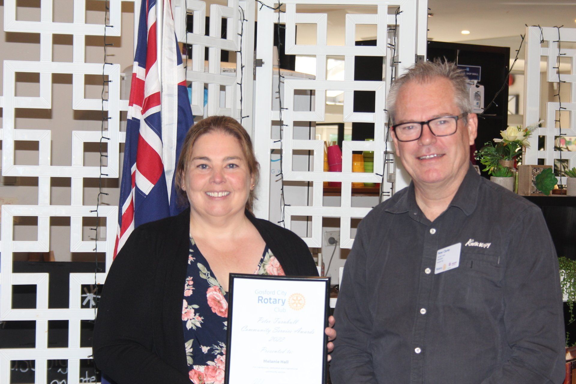 A man and a woman are standing next to each other holding a certificate.
