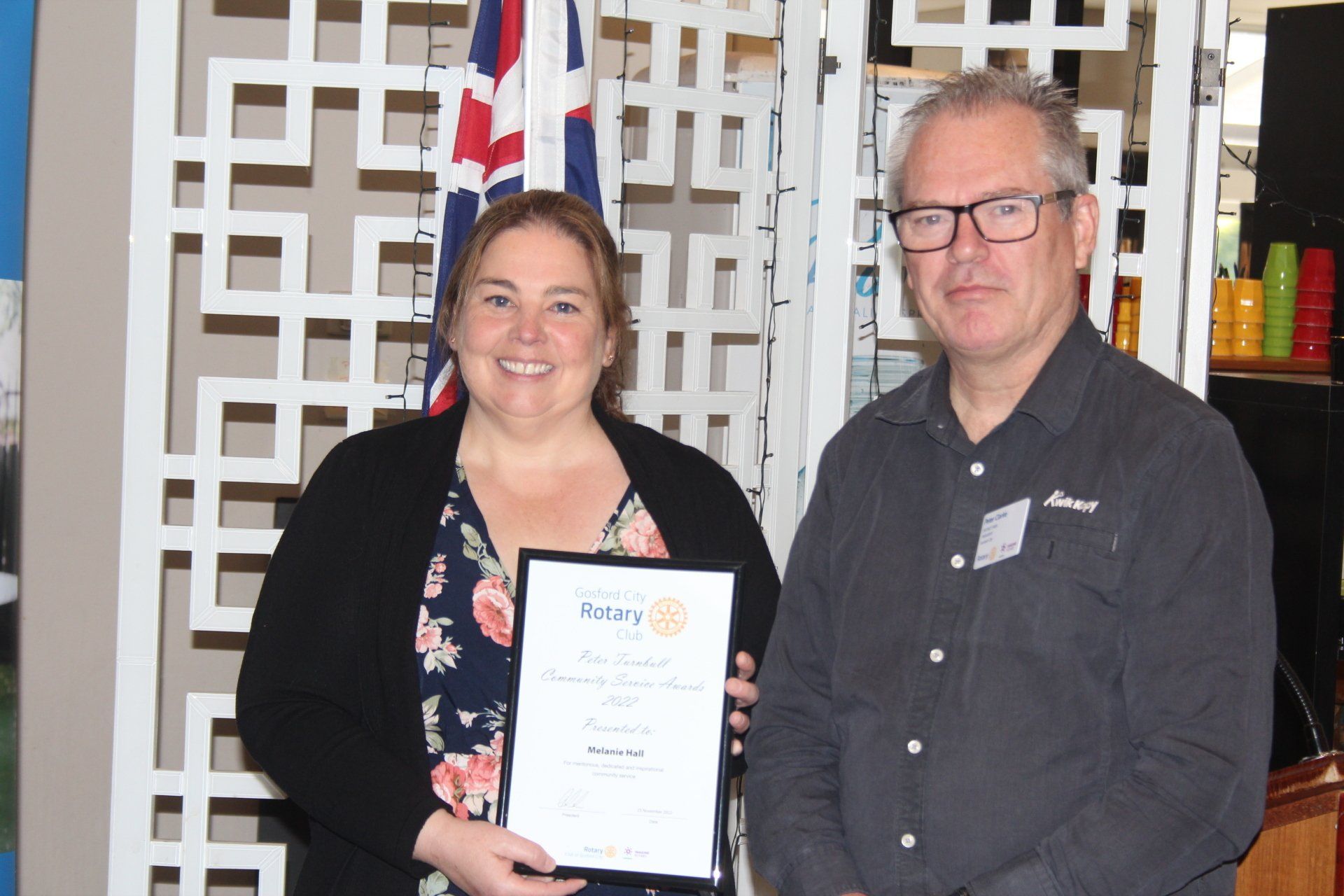 A man and a woman are standing next to each other holding a certificate
