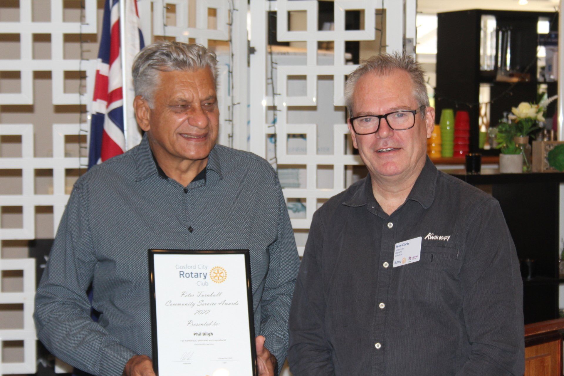 Two men are standing next to each other holding a certificate.
